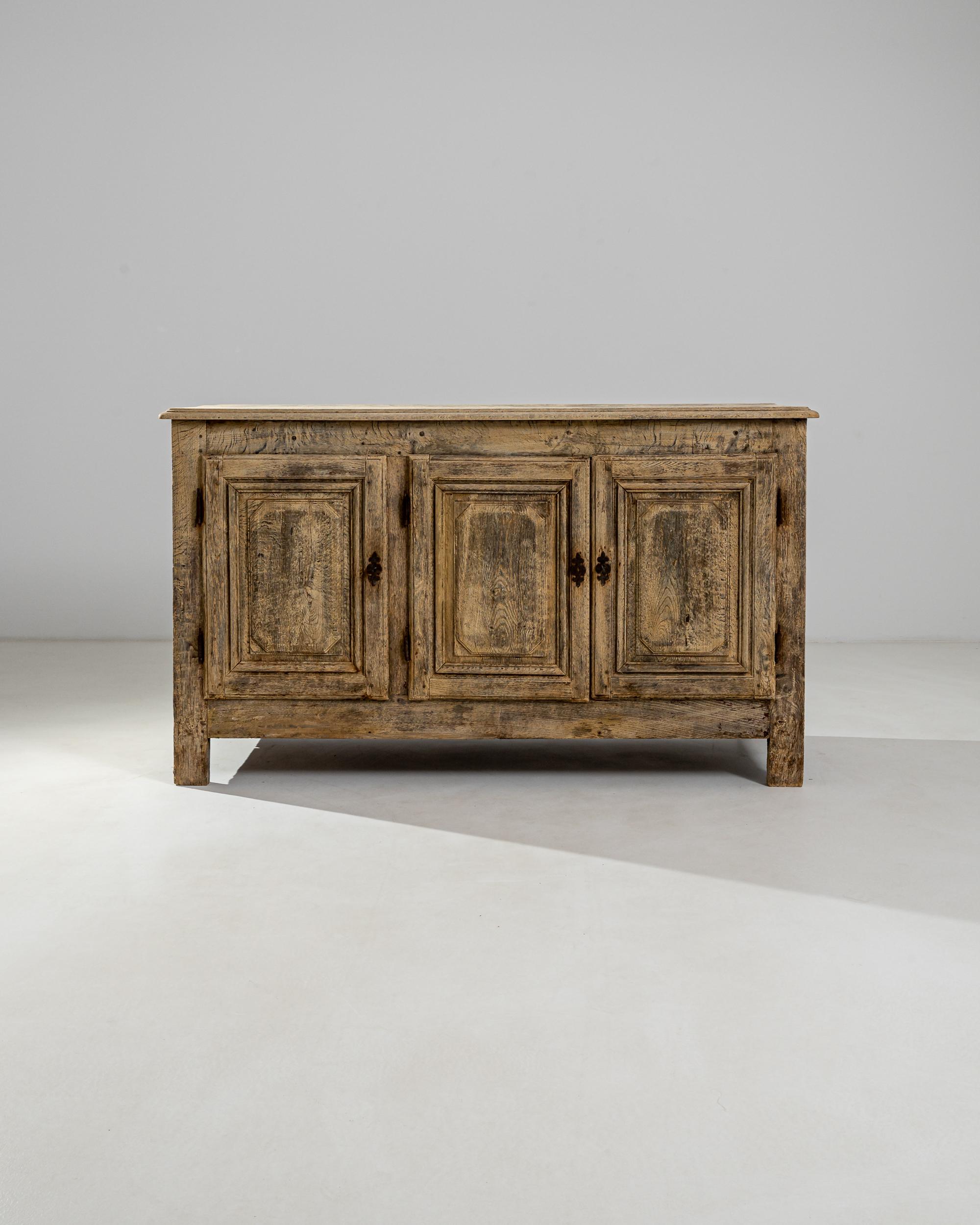 This handsome antique buffet in natural oak epitomizes the simplicity and sophistication of French Provincial style. Made in 19th century France, the shape is rustic and unaffected; subtle details such as the octagonal paneling on the cupboard doors