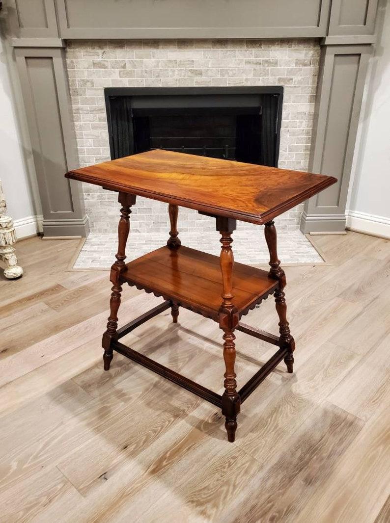 A remarkable Provincial two tier table with beautiful patina. Born in France in the mid-19th century, the Louis Philippe period table is rustic, yet elegantly refined, having deep, rich, highly figured burlwood rectangular top with stepped molded