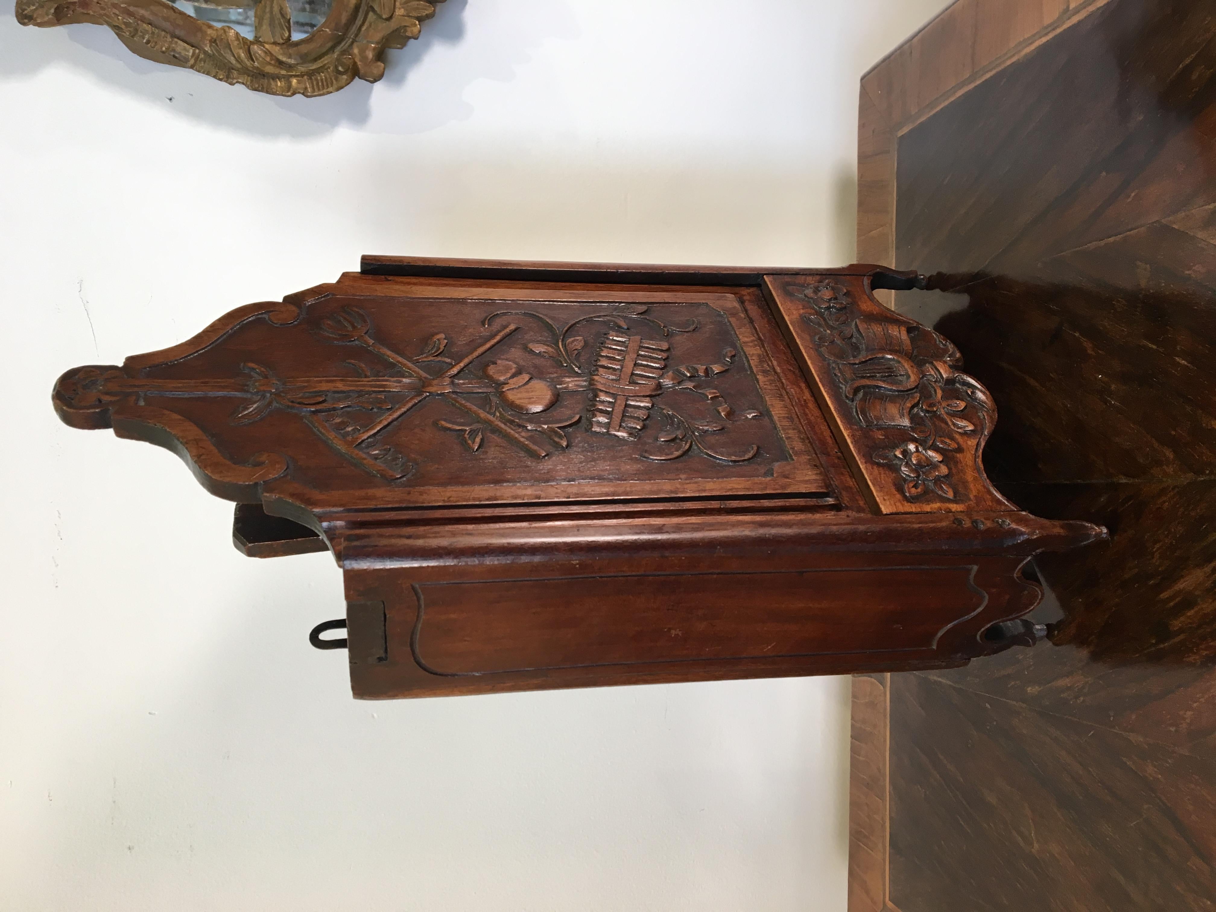 Fine 19th century French Provincial carved walnut fariniere in excellent condition. With ebullient farm and musical motifs, the body and sliding top supported by delicate cabriole legs terminating in balls. This richly carved piece has a beautiful