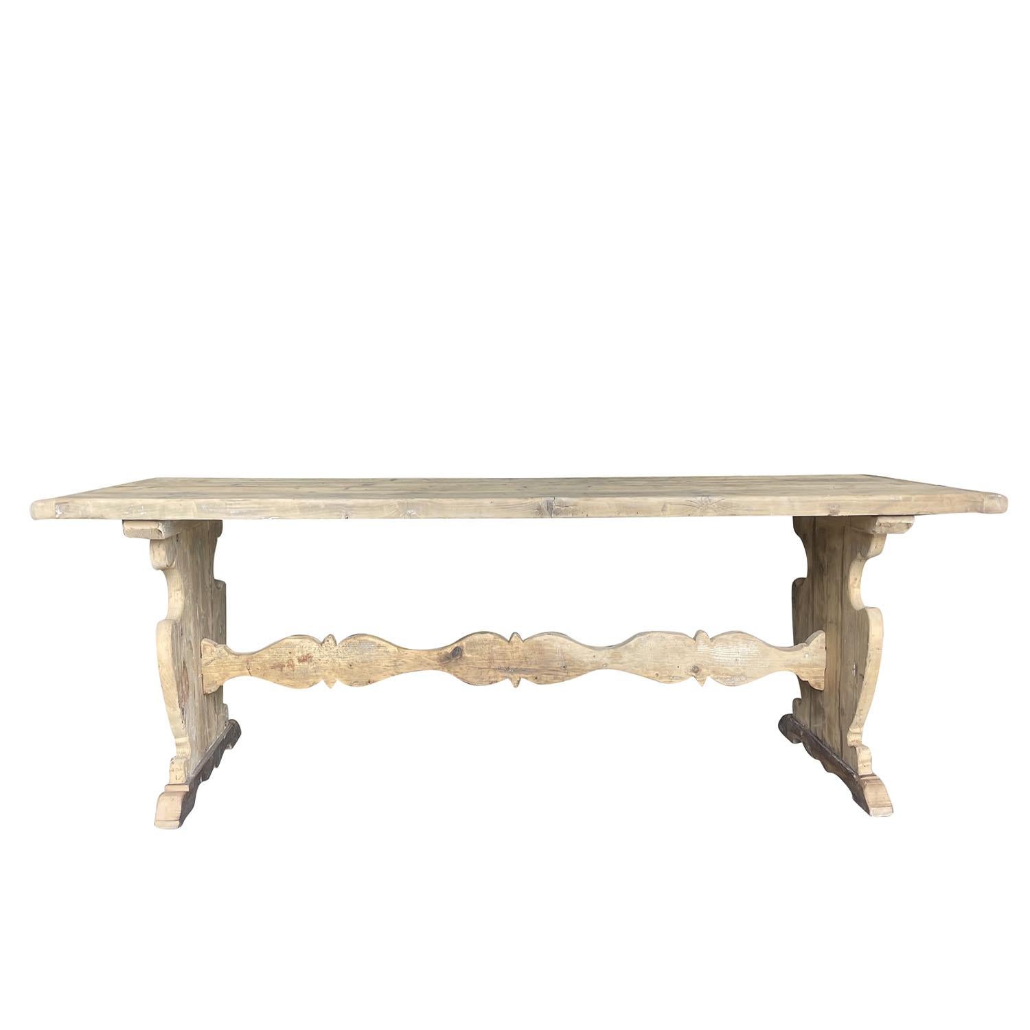Table de salle à manger rectangulaire ancienne de style provincial français, en bois de chêne blanchi à la main, en bon état. La base de style tréteau a des pieds épais de style balustre qui sont reliés par un long châssis. La patine antique usée
