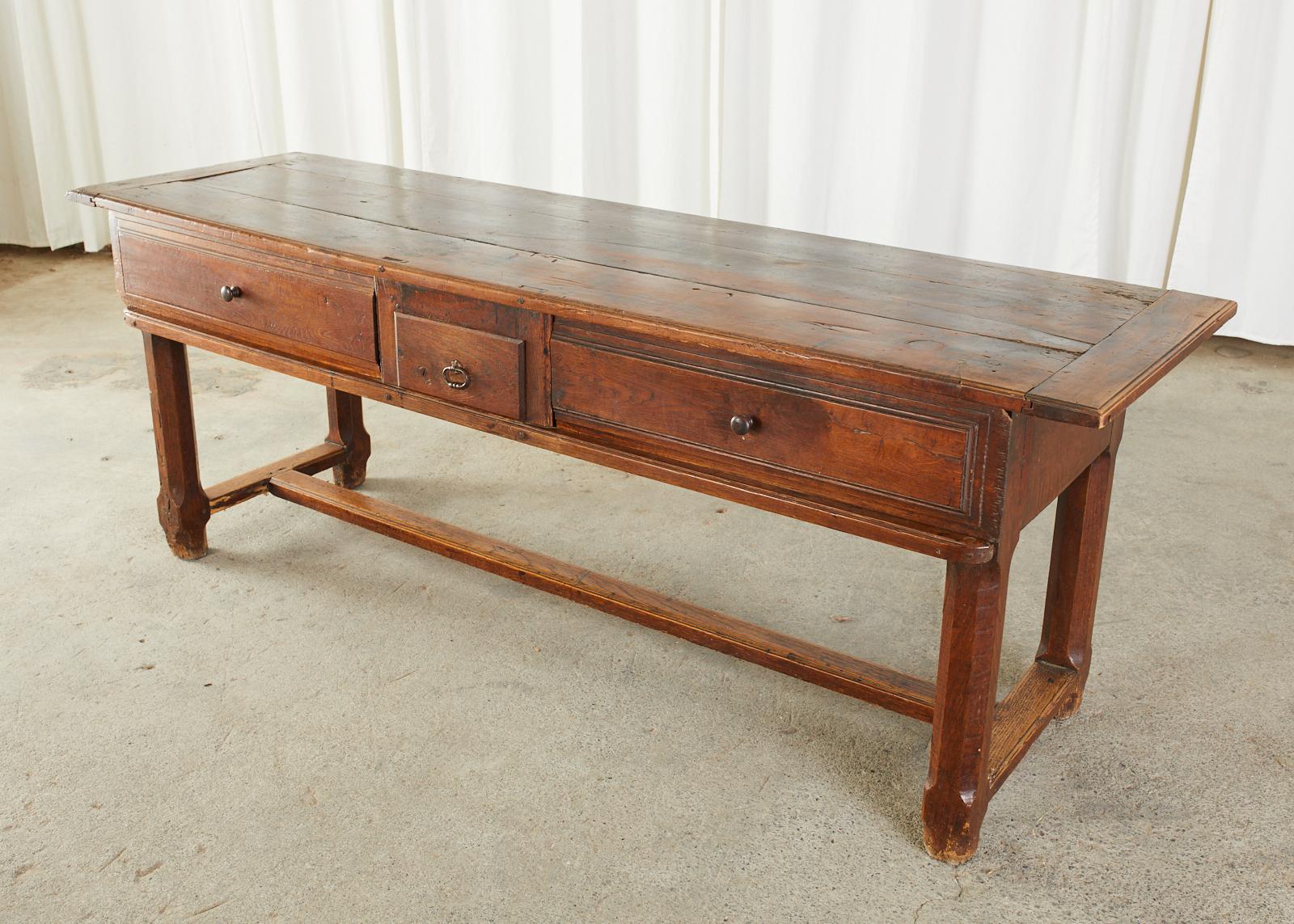Rustic 19th century country French provincial farmhouse work table or console table. Mixed wood construction of oak, walnut, and fruitwood featuring a thick plank wood top having breadboard ends with tongue and groove joinery. The table has a
