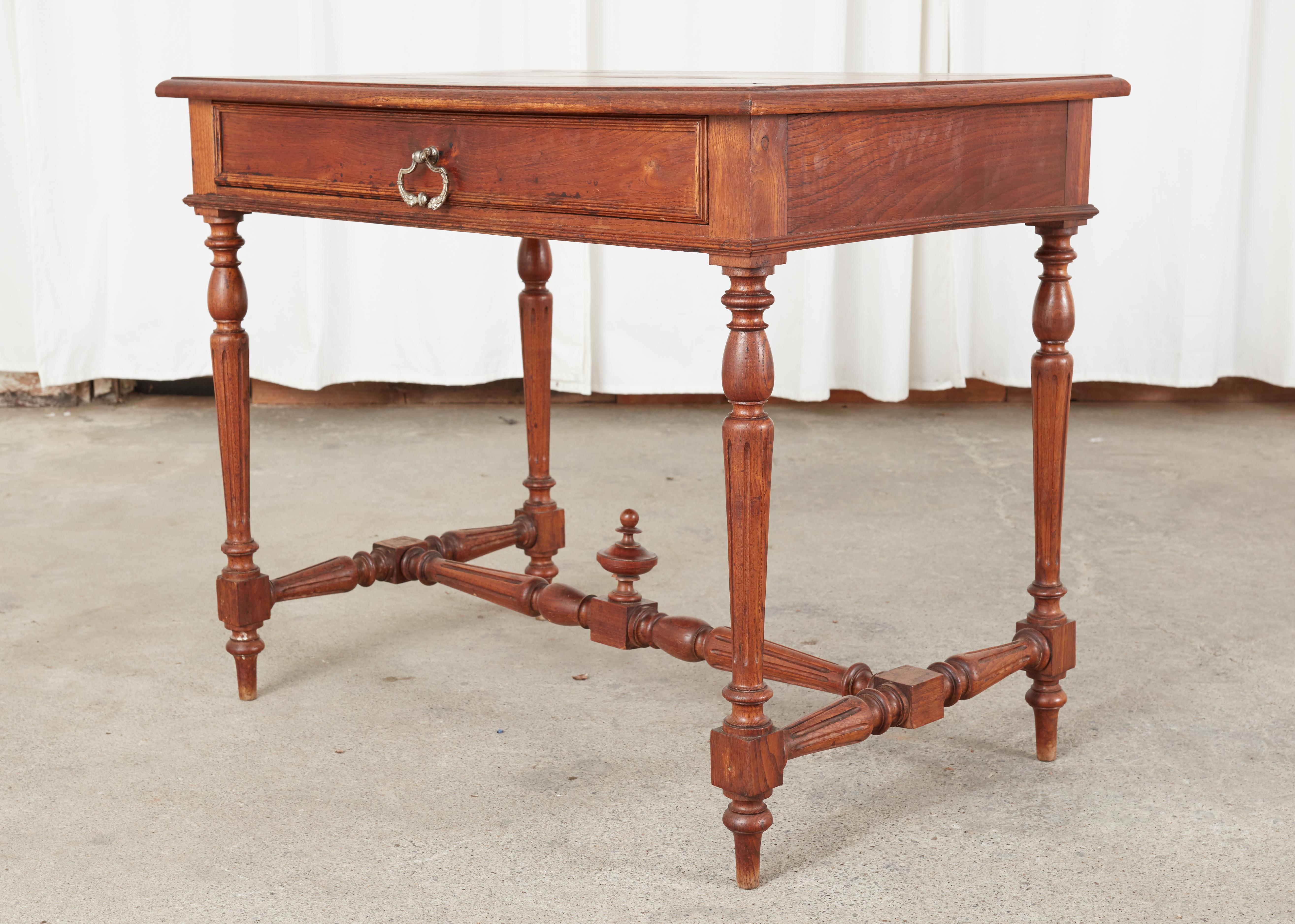 Diminutive size 19th century French provincial writing table or desk. The table is constructed from fruitwood with a warm patina and lovely wood grain patterns. Fronted by a single storage drawer in the front the case is supported by elegant tapered