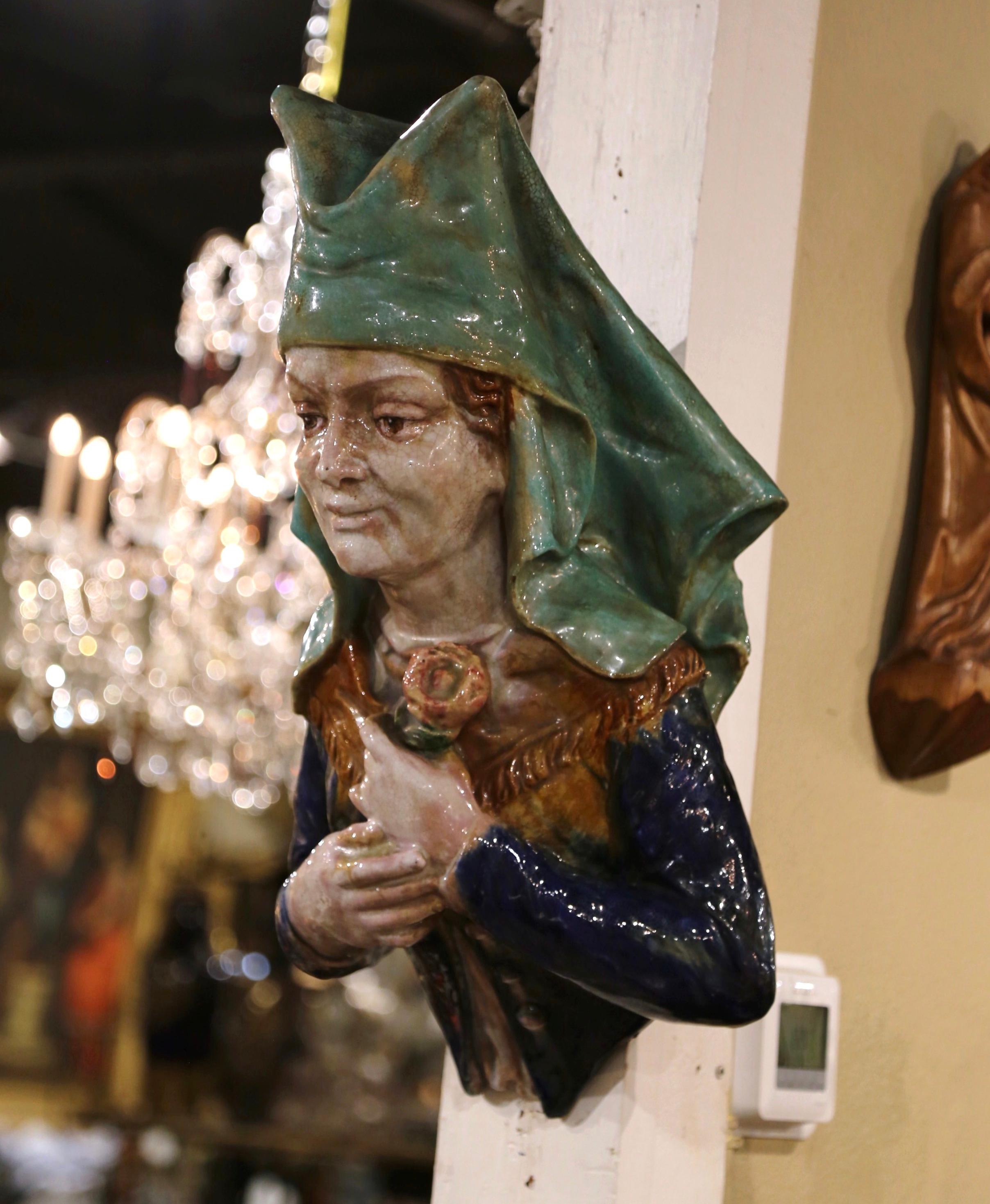 This beautiful bust would make any wall interesting and unique, adding a touch of feminine, old-world charm. Crafted in southern France circa 1880, the large antique wall-hanging statue depicts an older woman dressed in a blue top with brass-colored