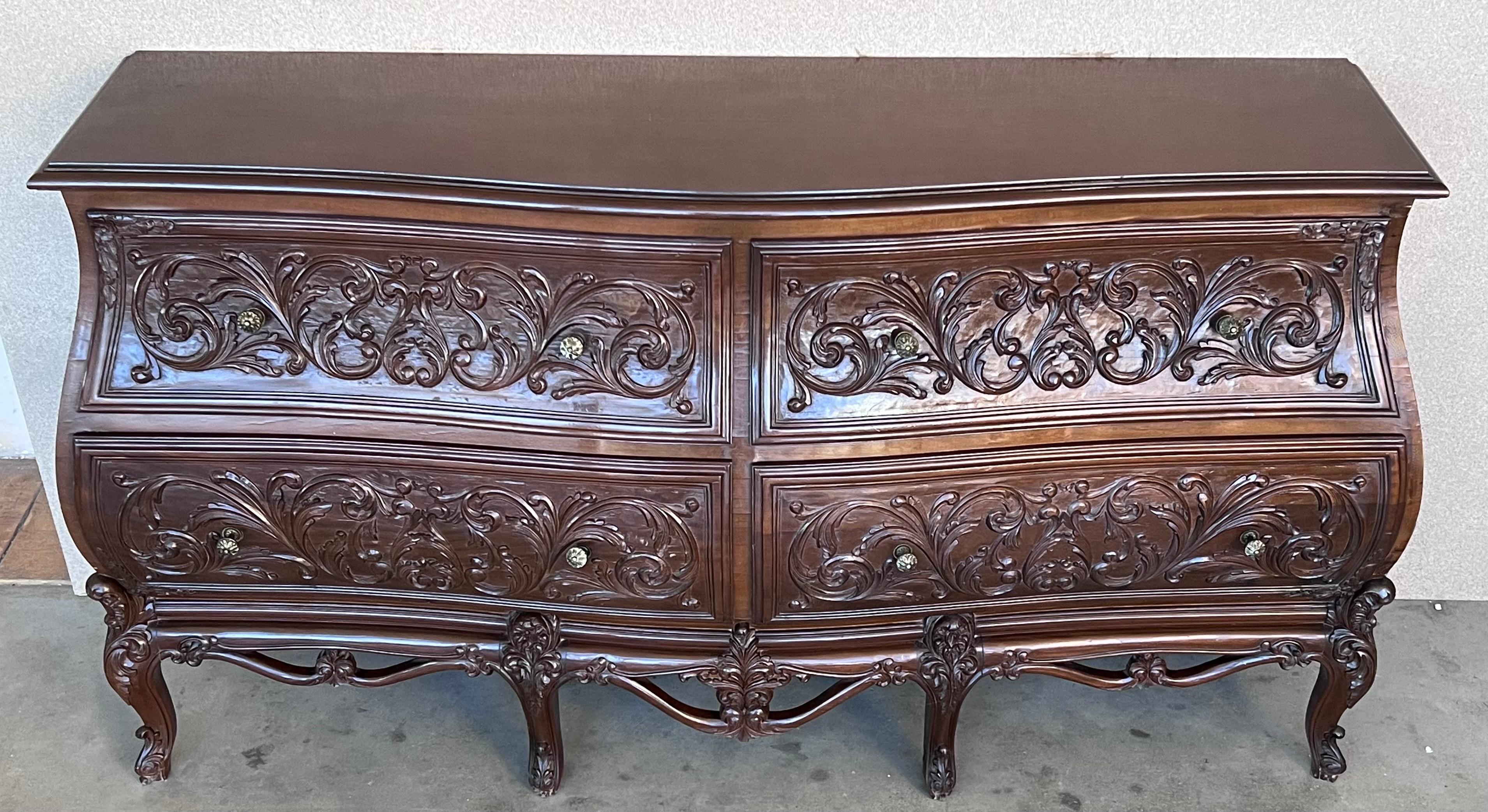 A finely carved late 20th century walnut commode in the French provincial Louis XV style particular to Nimes. The commode of bombe form with carved canted corners flanking four long drawers, each decorated with carved cartouches that frame the