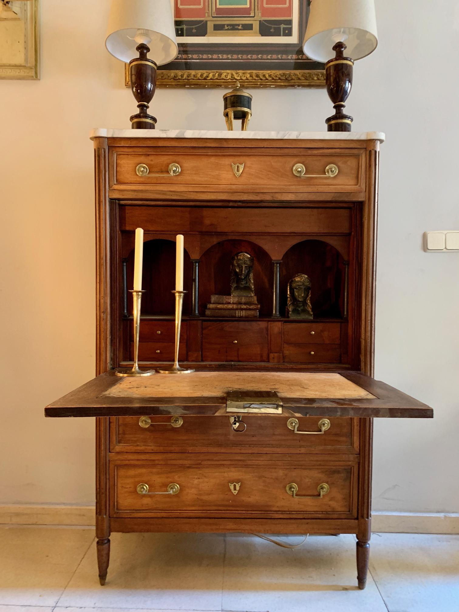French Louis XVI secretaire desk in blond walnut with original white marble top, It has three drawers, one at the top and two at the bottom, on the front opens a table covered with original leather with five small drawers and small shelves with