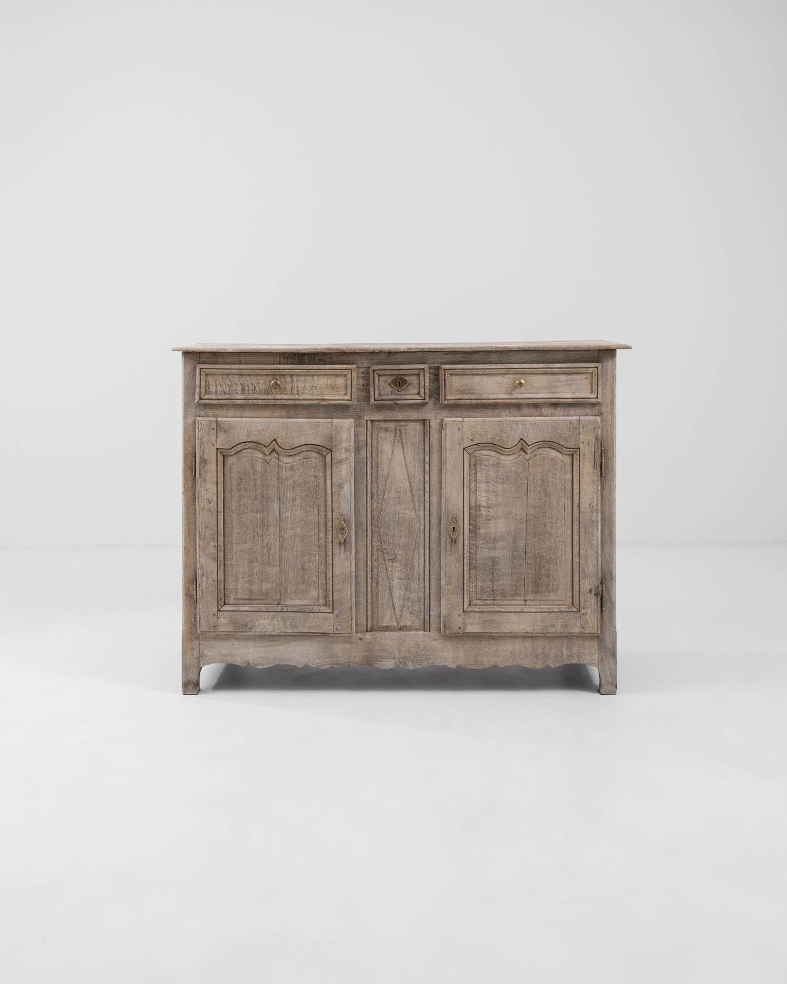A wooden buffet created in 19th century France. Bright, ornate, and beautifully constructed, this distinguished buffet greats one with a refreshing sense of calm. A careful bleaching process has been applied to the surface of the oak, which both