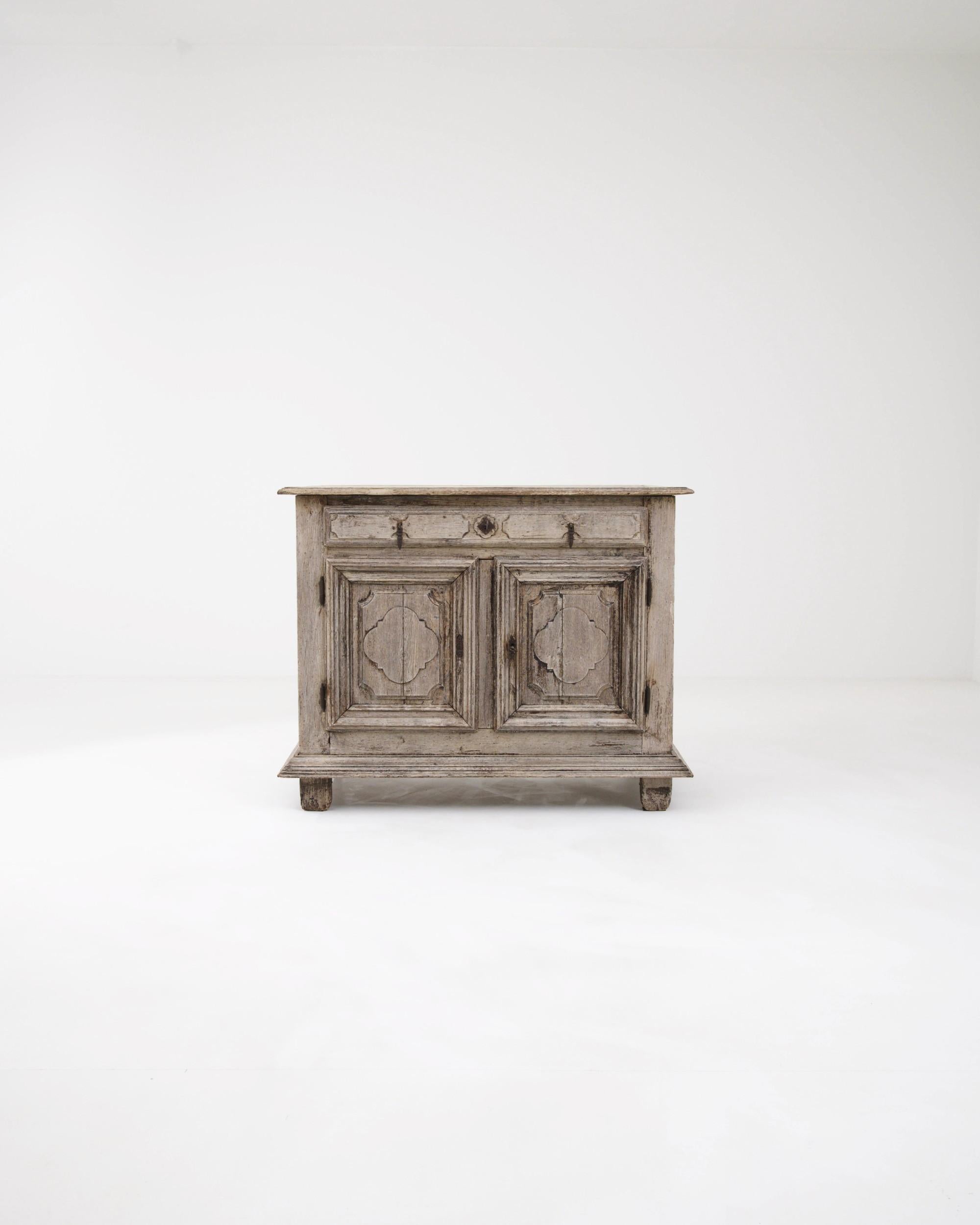 Ornamental accents give this Provincial oak buffet a uniquely charming personality. Hand-crafted in France in the 1800s, the silhouette is simple, providing ample space to store the humble items of a country household. The deep relief of the