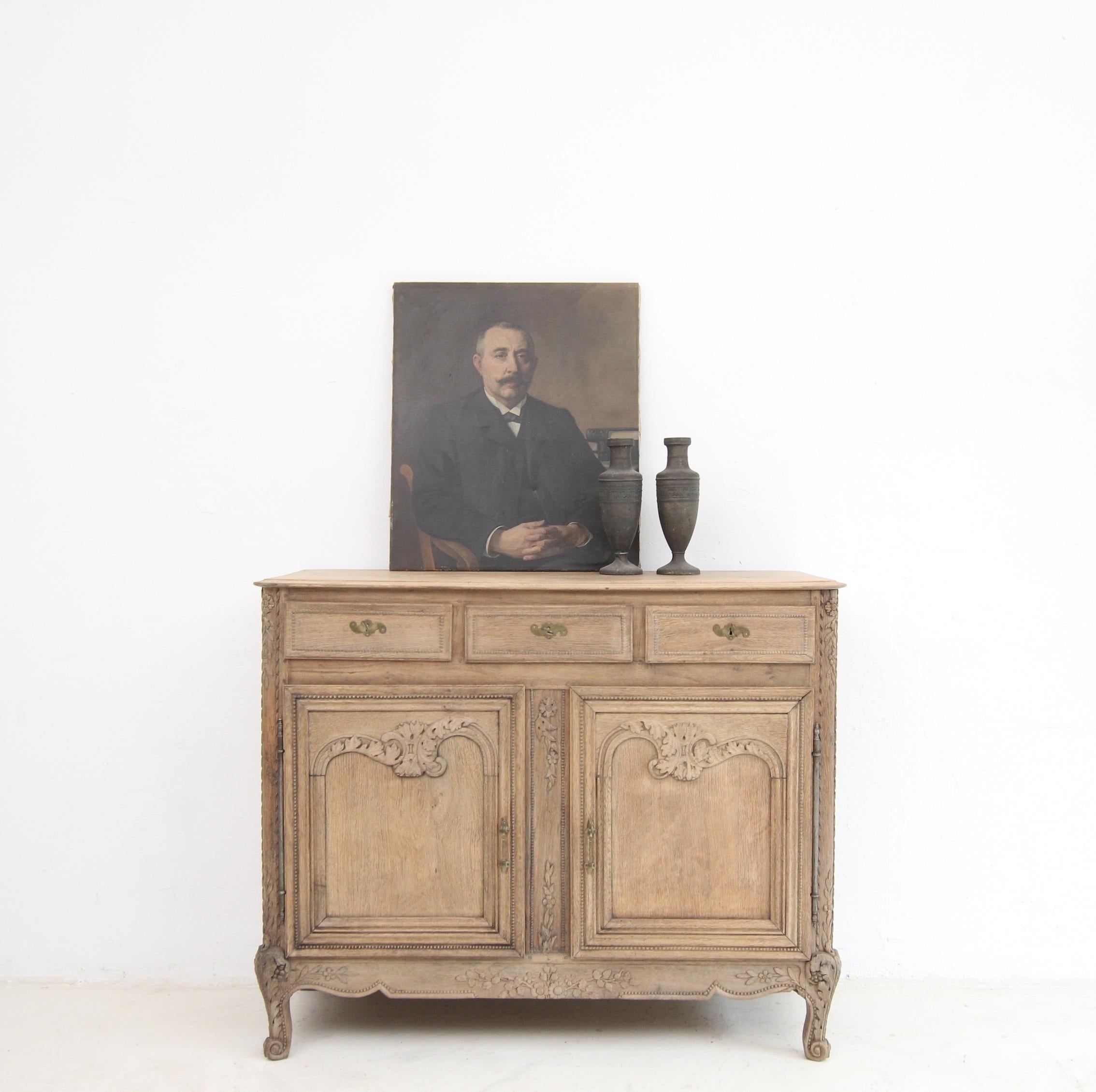 A 19th Century French provincial sideboard or buffet in Louis XV style. Made of solid oak. 

Traditionally crafted oak body with 2 doors, 3 drawers and a slightly protruding moulded top. Florally carved front with beadwork decoration on the centre