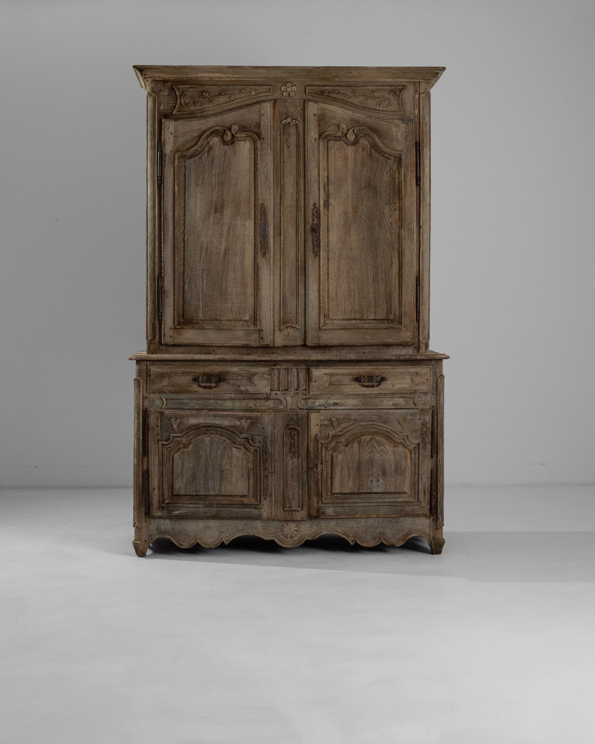 Verdant and romantic, this antique oak cabinet blossoms with floral details. Built in 19th century France, the simple provincial silhouette is enlivened by intricate carvings: a daisy blooms from the center of the contoured apron, the lines of the