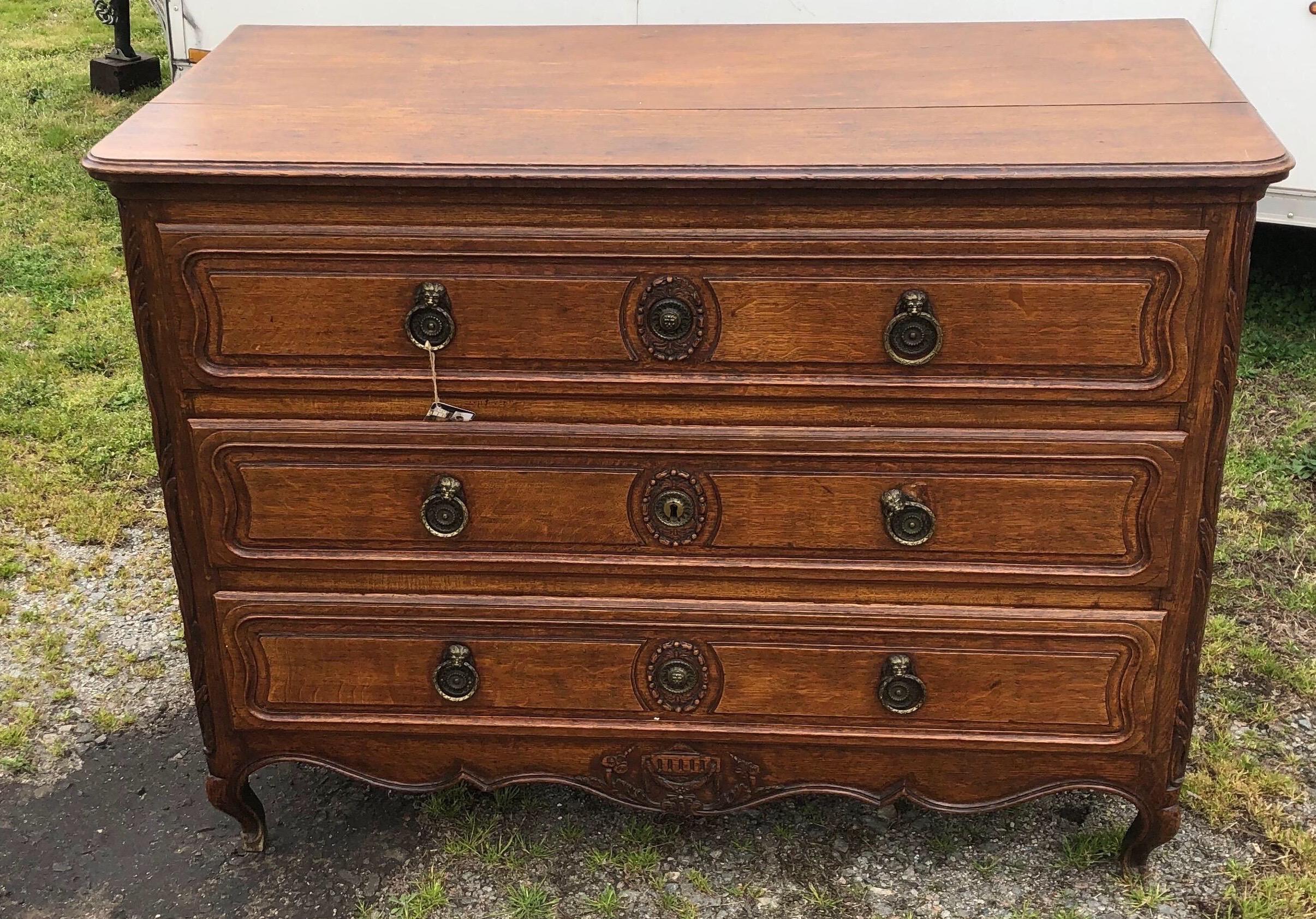 19th century French Provincial oak commode with three drawers, carved knees and feet and three board top.