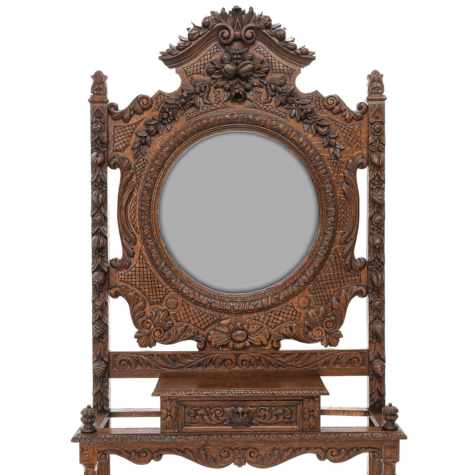 19th century French Provincial Oak Hall Tree, Finely Carved Details, Sides Having Carved Acorn Caps and Feature Carved Fruit and Floral Accents in a Gibbons Style, Center Having Round Beveled Mirror Surrounded by Carved Moulding, Carved Diaper
