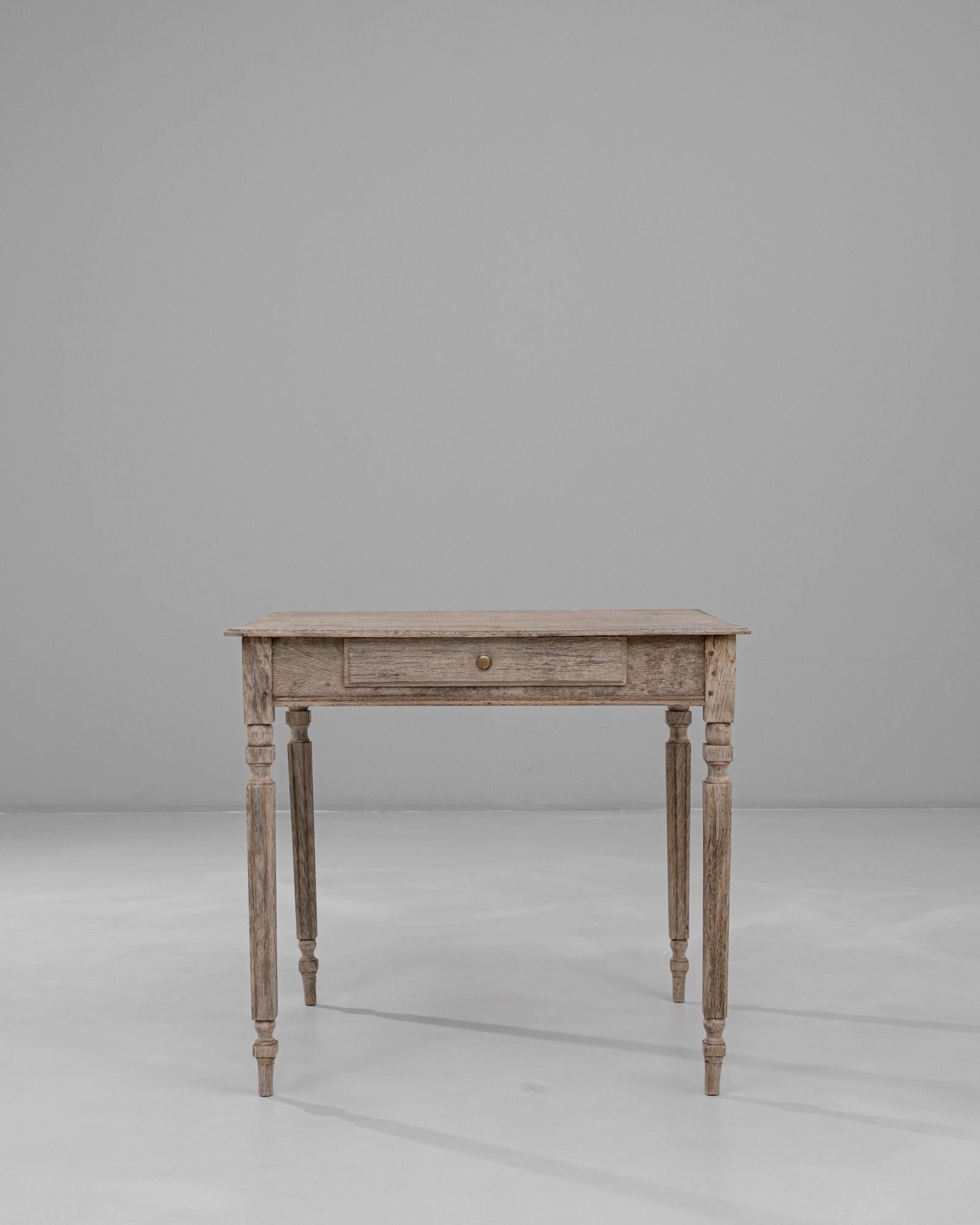 This 19th Century French Provincial oak side table showcases the understated charm and utility characteristic of rural craftsmanship. Its lightly weathered oak surface retains a soft, natural patina that highlights the grain without overpowering the
