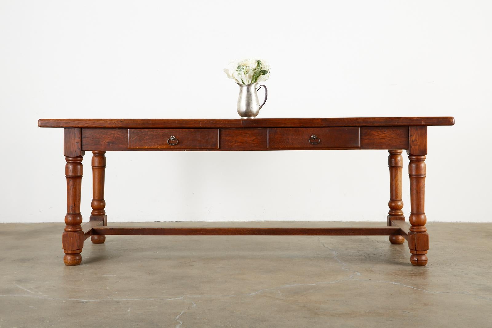Quintessential 19th century country French Provincial farmhouse dining table. Constructed from rich oak with wood peg joinery. The top features 1.75 inch thick solid planks of oak with radiant grain patterns and knots. Supported by a substantial