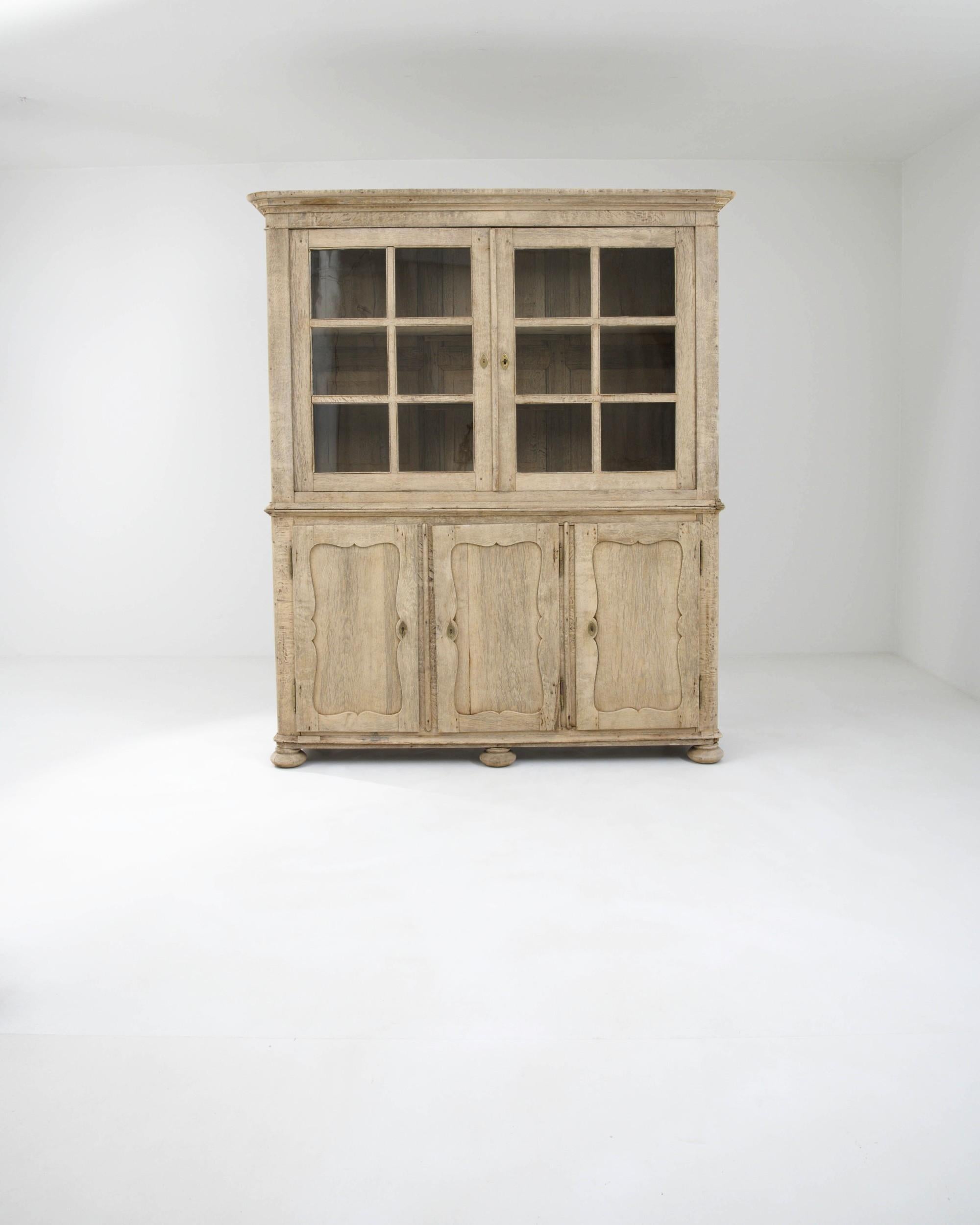 Beautiful craftsmanship and a fresh natural finish make this antique oak buffet a find to treasure. Hand-made in France in the 1800s, this piece would have once been the pride of a Provincial household. The mullioned windows of the upper cabinet