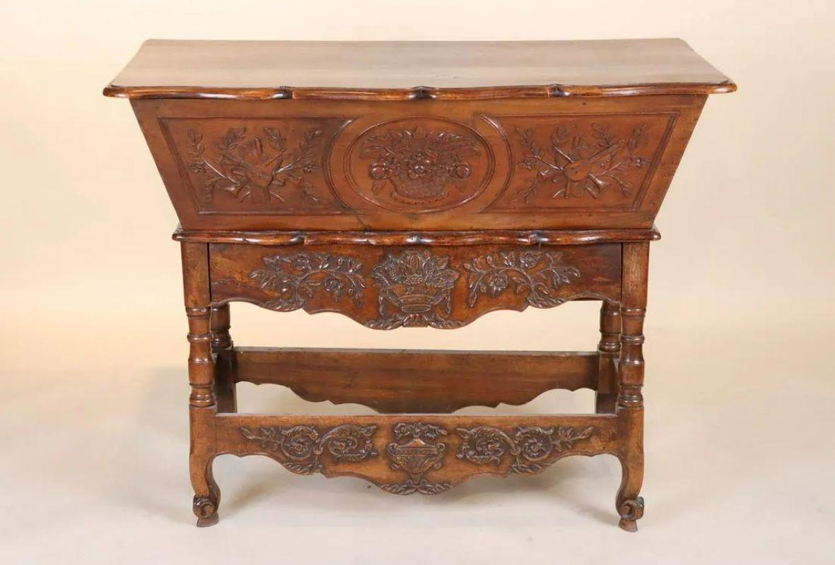Table à pâte en noyer de style provençal du début du 19e siècle, avec un tiroir sous un bac de rangement à plateau élévateur, ornementalement sculptée. Ils étaient souvent placés sous un Panettiere (coffre à pain) suspendu au mur.