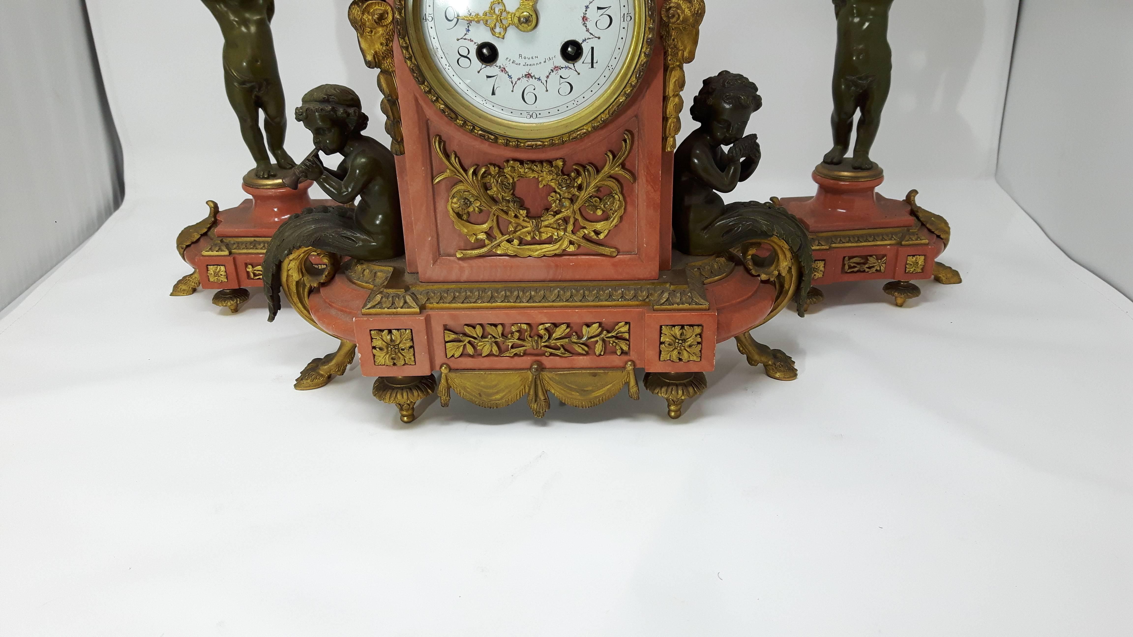 A fine quality three-piece French gilt red marble and bronze clock set comprising
two three branch candelabra and a mantel clock.
The clock has a white enamel and floral offset by ormolu mounts.