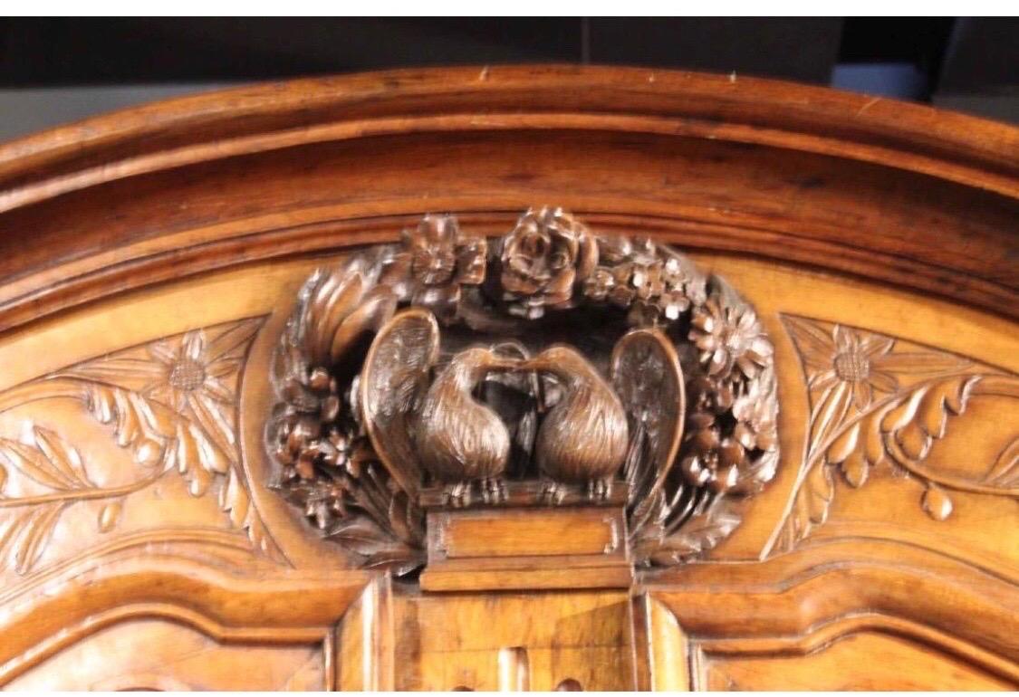 19th century French provincial walnut and cherry armoire with carved doves representing a marriage.