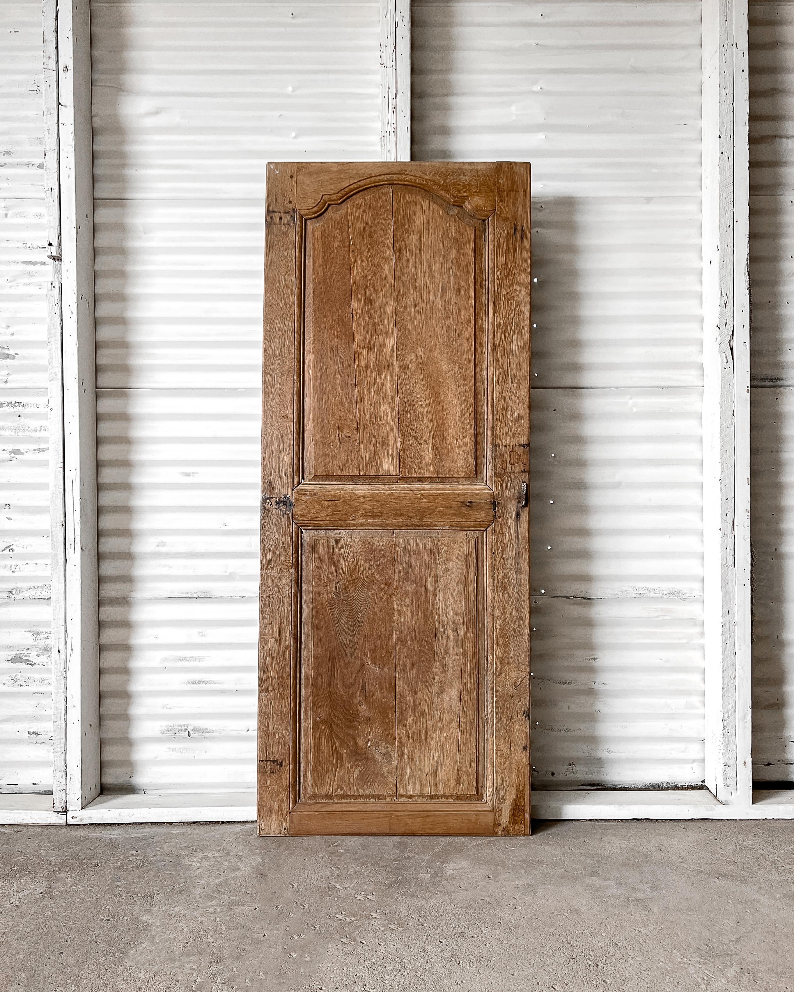 19th-century French provincial wardrobe door with carved upper panel and grooved beveled trim detailing. Install in a new home to enclose a pantry or linen cupboard to instantly add a layer of charm and character that can’t be replicated with modern