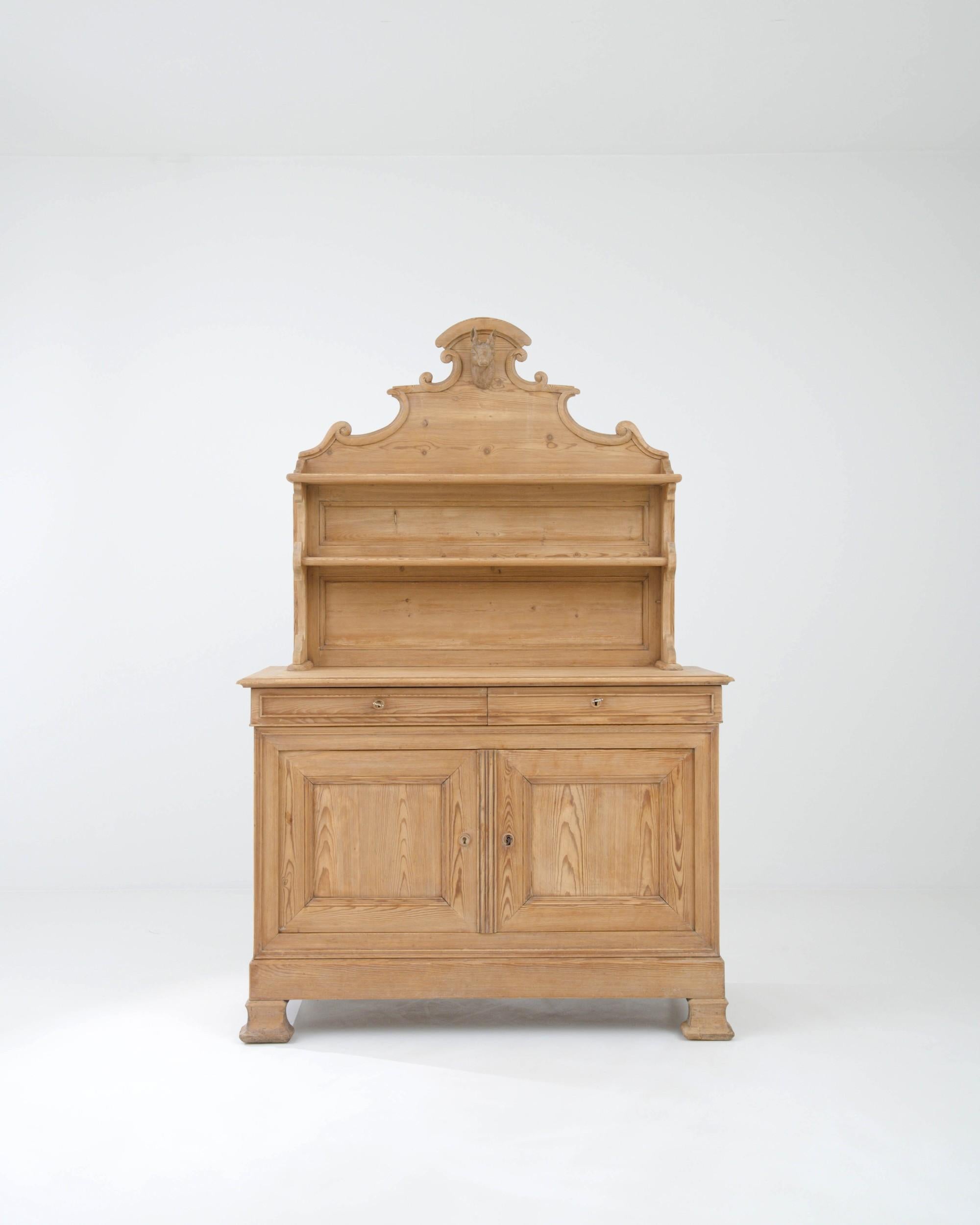 Masterful craftsmanship and a natural golden finish makes this antique wooden dresser a heirloom to be treasured for generations to come. Built in France in the 1800s, the design combines a spacious lower cupboard with a set of upper shelves, which