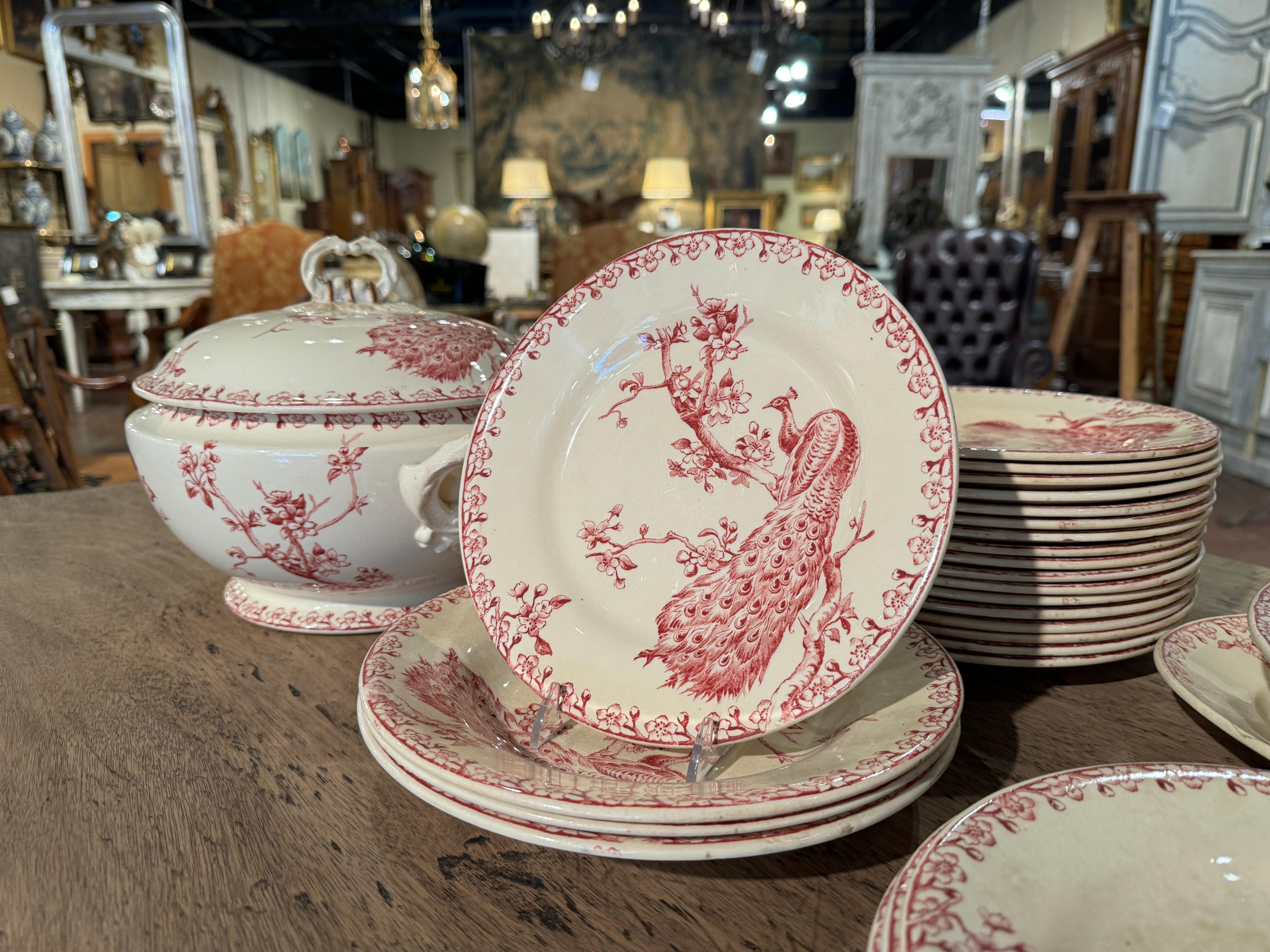 Decorate a dining table or shelving with this antique porcelain service set of 32 pieces. Crafted in France circa 1880 by Gien, each plate and dish features a large peacock, and is stamped on the bottom 
