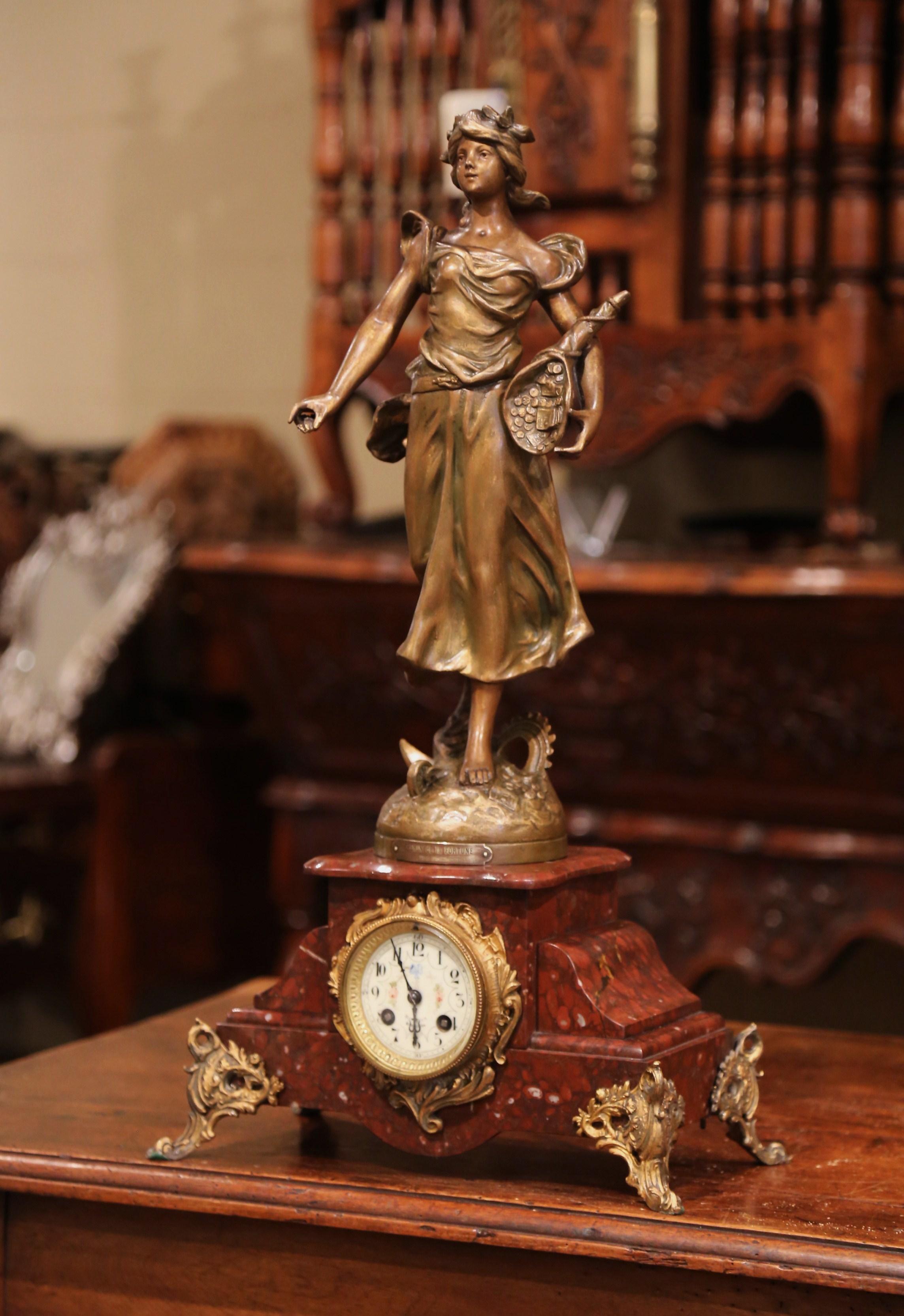 Decorate a mantel or a shelf with this elegant antique clock. Crafted in France circa 1870, the mantel clock sits on small scroll feet over a rouge marble base and features a statue of a young beauty, the work of art, titled 