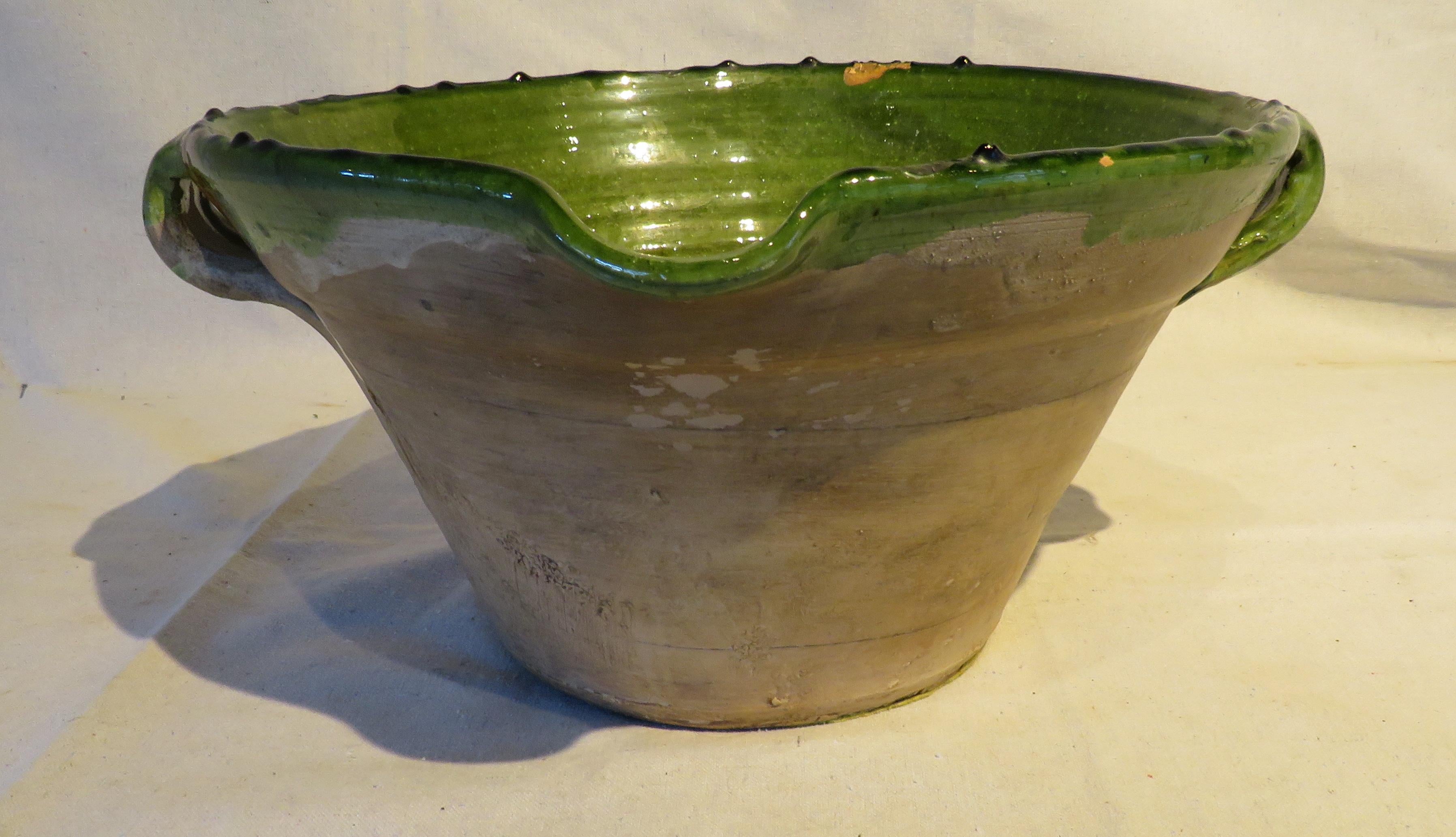 19th century French redware tian bowl with inside green glaze, serving spout, and natural finish on the exterior. 

Traditionally used to prepare confit in South West France, this type of bowl was also used to prepare other various foods from the