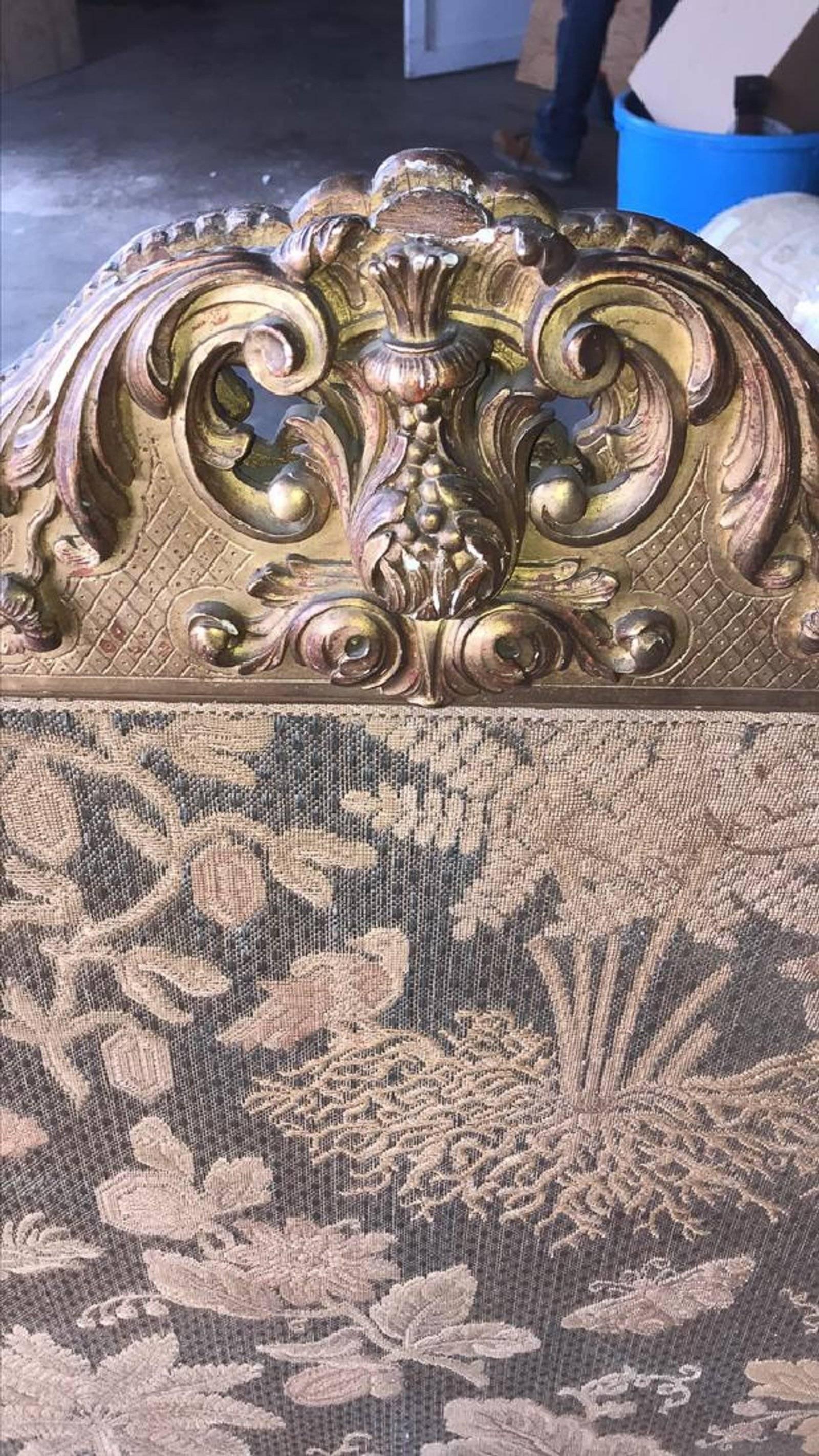 19th century French Regence giltwood firescreen with ornately carved framed done in a flower spray, leaf scroll, and shell motif. The inset panel decorated with a treed and flowering landscape with birds and butterflies.

Provenance: The late
