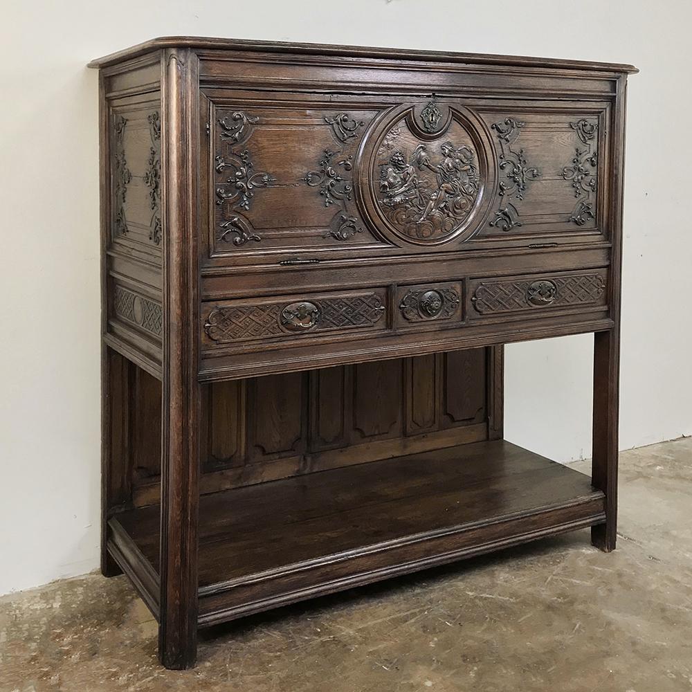 19th century French Regence Secretary, dry bar was sculpted from select French oak, and features elaborate detail including a scene depicting a wife sending her warrior husband off to battle at the center. Raised on legs with a lower display shelf,