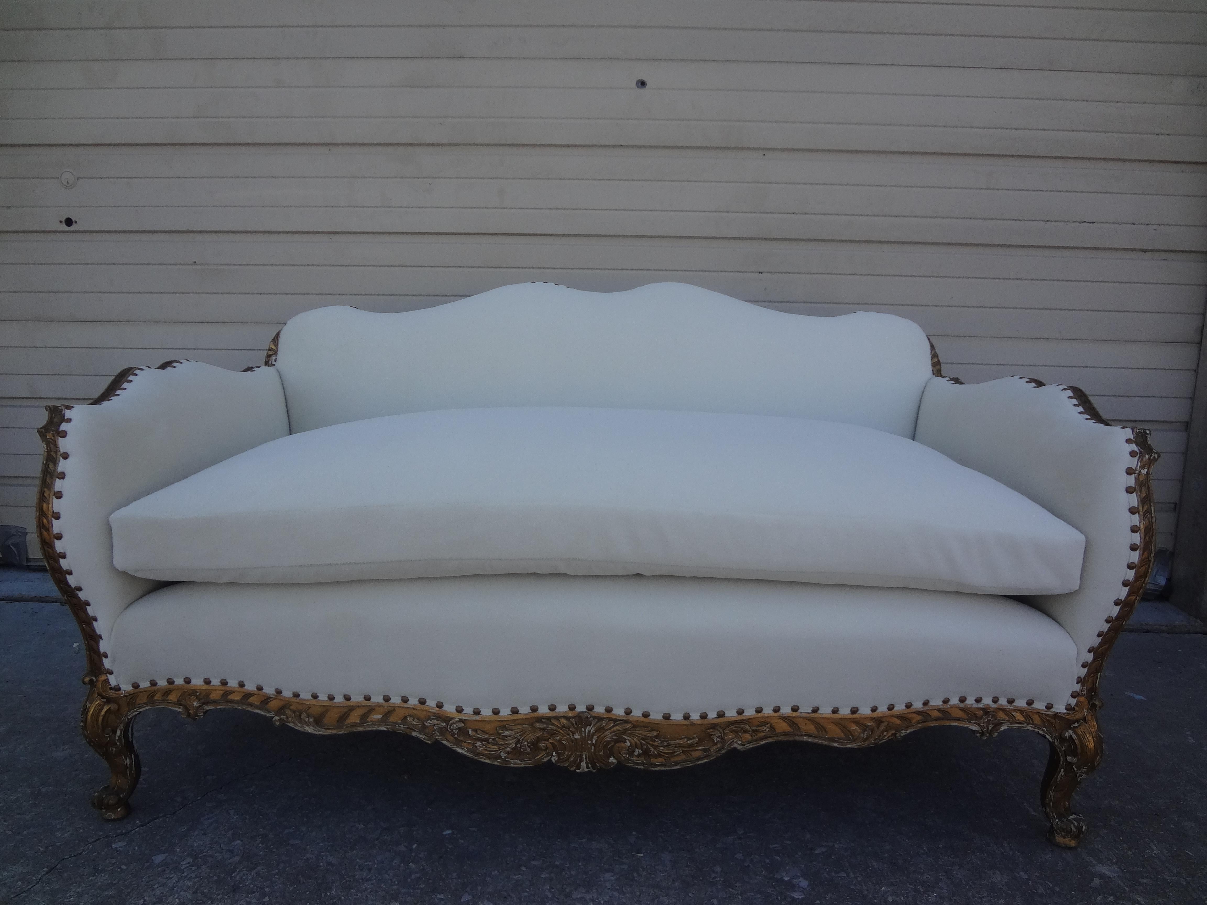 19th century French Régence style giltwood loveseat or sofa. This stunning most unusual antique French Regence style or Napoleon III gilt wood loveseat, canape or sofa has been professionally upholstered in a plush white low pile mohair type fabric.