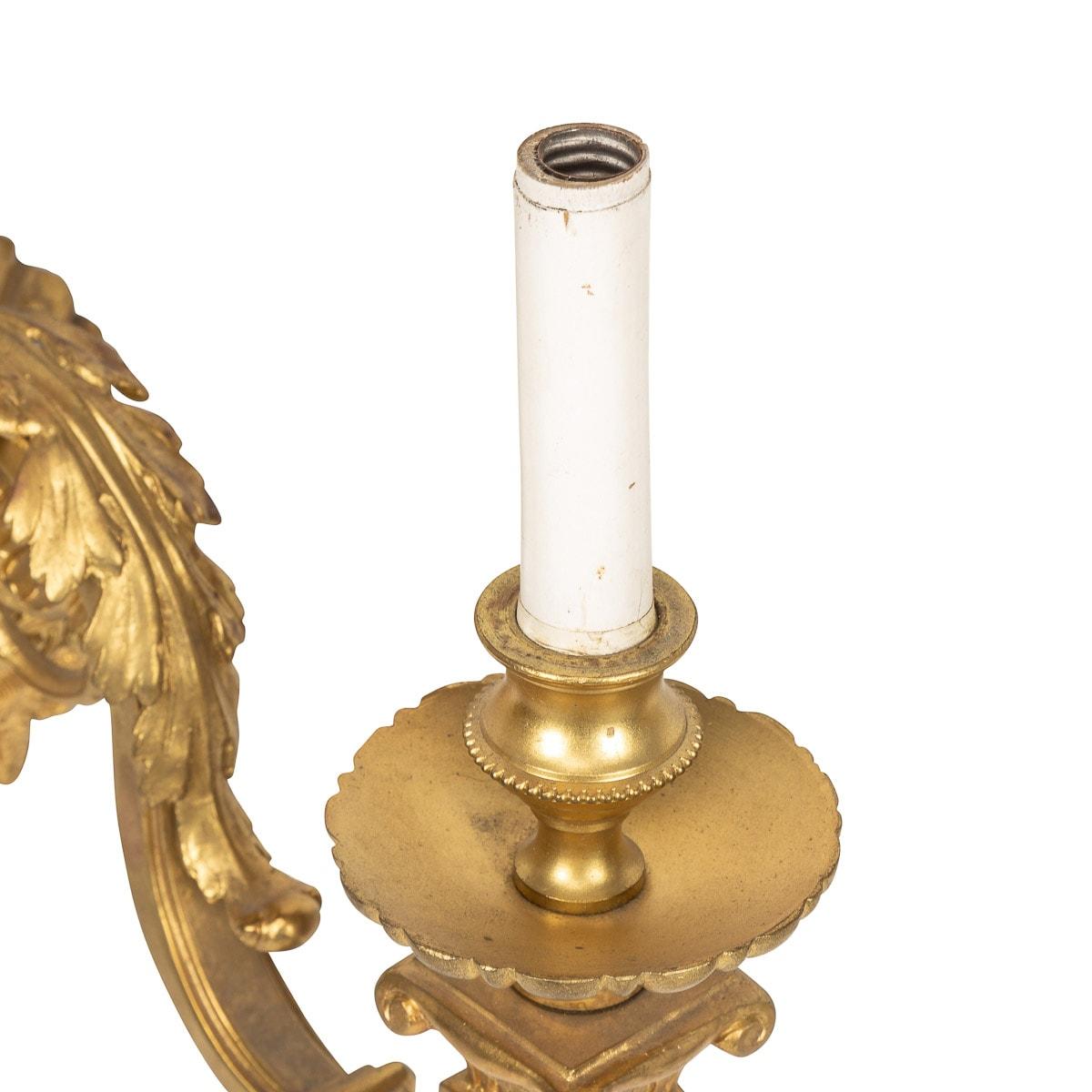 Antiguo par francés del siglo XIX de apliques figurados de bronce d'appliques montados en la pared. Este par de luces aplicadas con máscara femenina con brazos emergentes por encima que sostienen las ramas de luz gemelas adornadas con hojas de