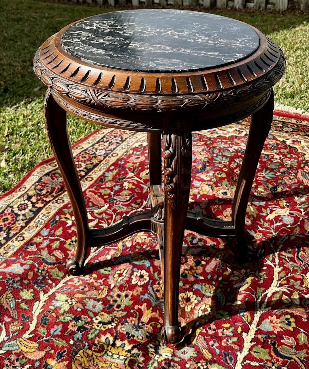 19th Century French Regence Style Round Marble Top Side Table.

This French 19th Century table features ornate carving and a round marble inset top.  The beautiful black marble is accented with gold and white veining. The walnut table stands on four