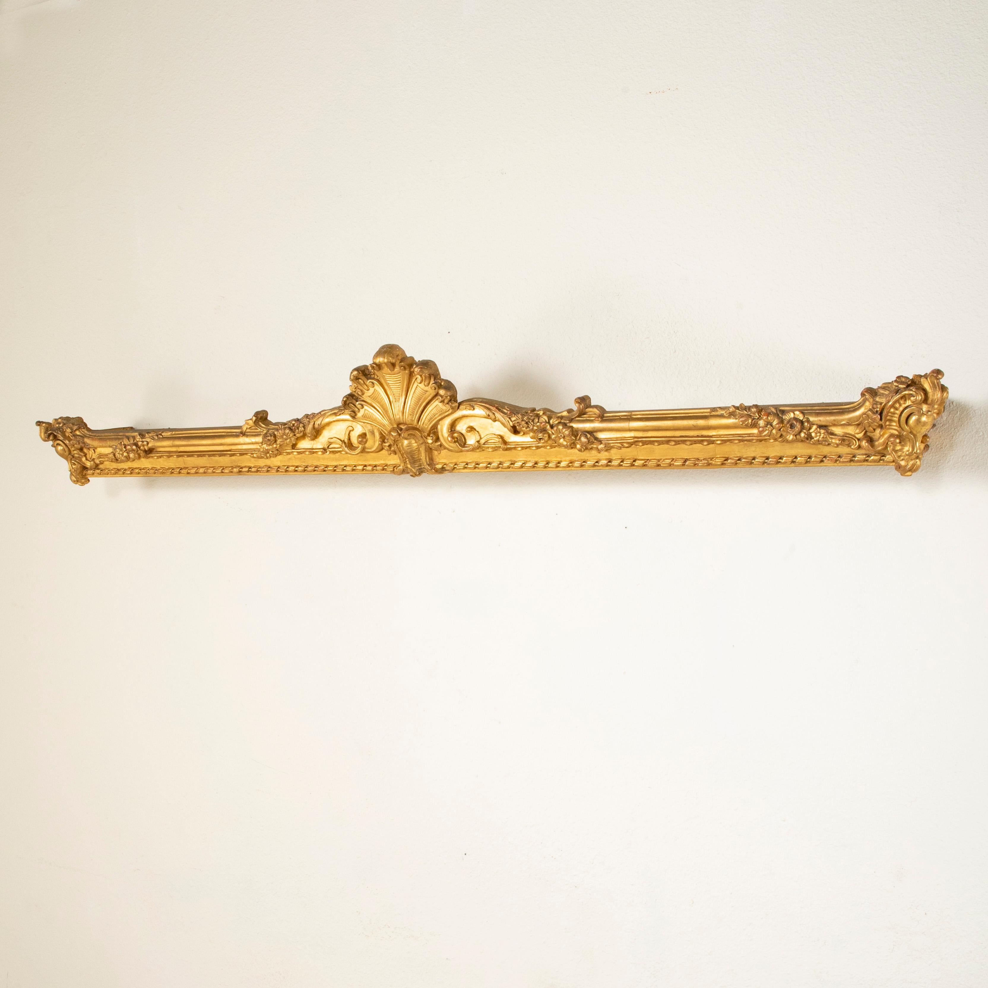 This late nineteenth century Regency style window cornice of hand-carved gilt wood was originally used as a drapery valance in a French chateau. Featuring a classic Regency style central palmette flanked by scrolling leaves, this unique piece is