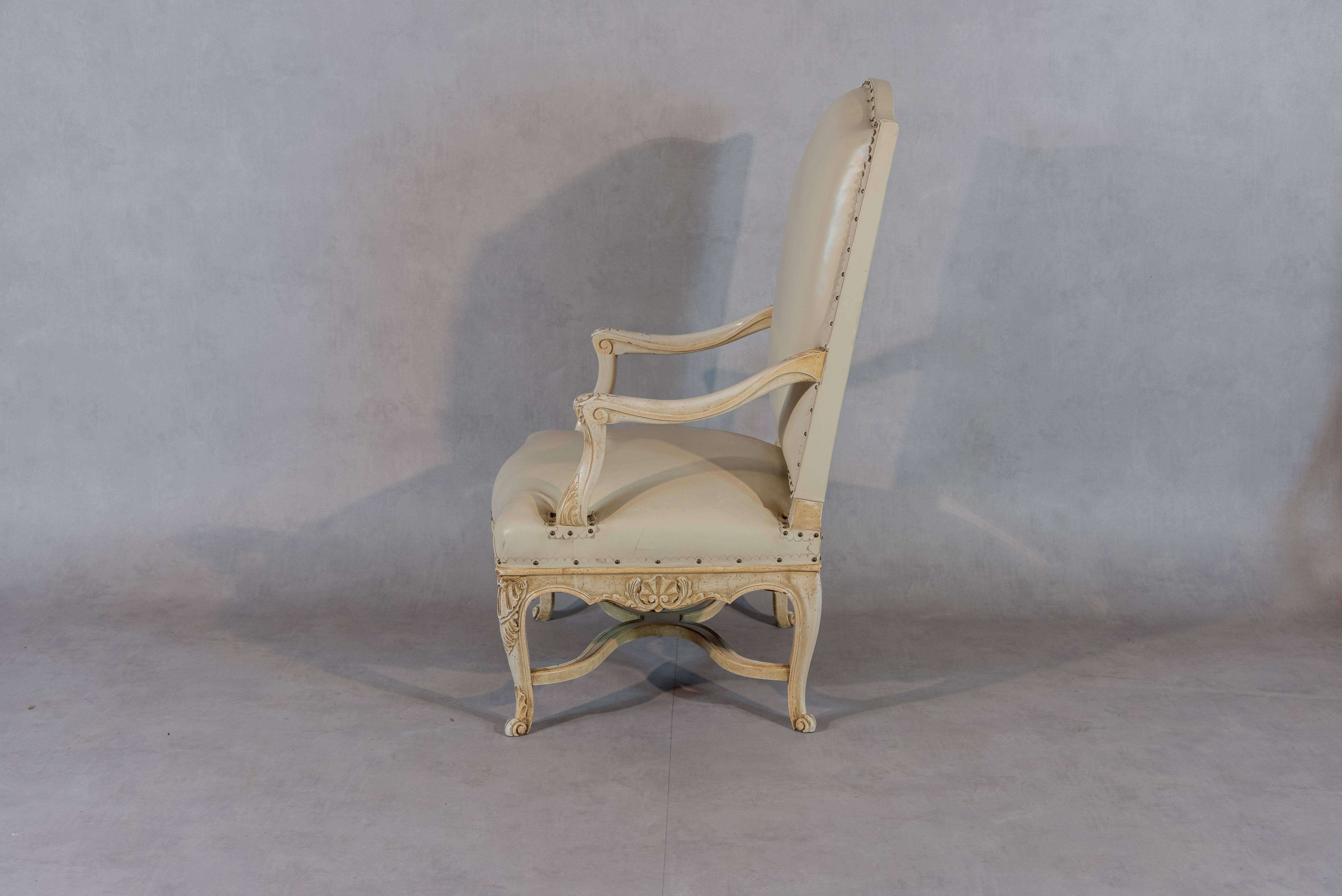 This elegant 19th century French Regence Style armchair is a true masterpiece in design and craftsmanship. Upholstered in luxurious leather and adorned with a stunning nailhead trim, the chair is beautifully paired with the oak frame of the chair,