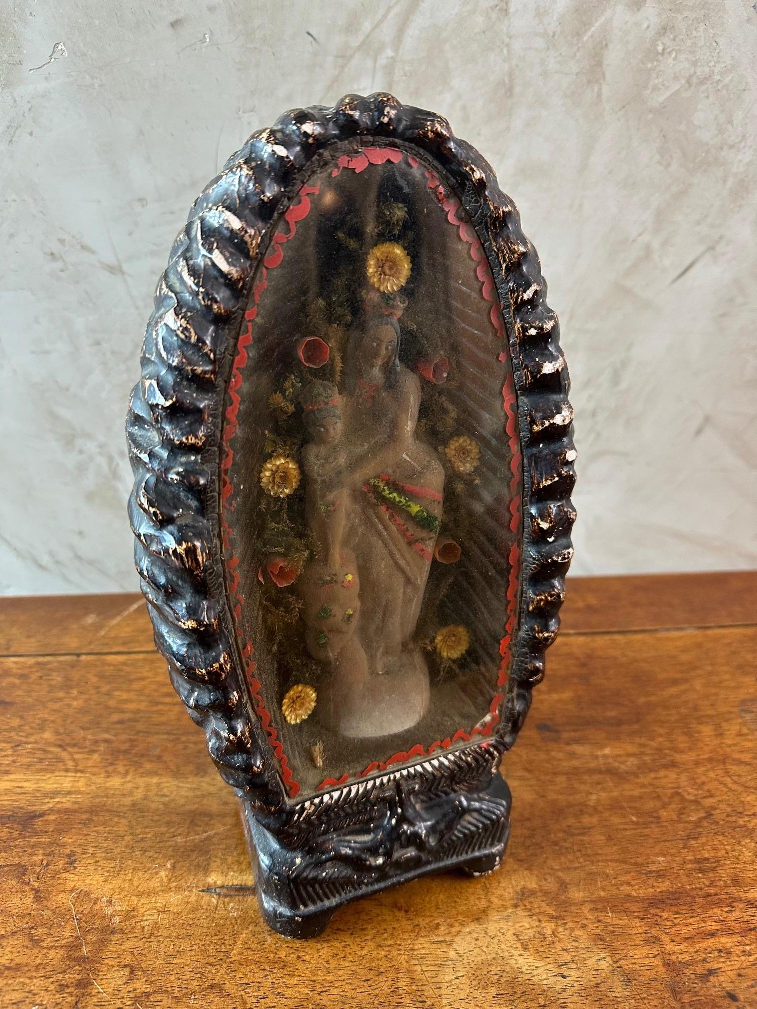 Beau reliquaire du 19e siècle représentant une vierge à l'enfant entourée de fleurs et encadrée dans un cadre en terre cuite vernissée. Verre décoré d'une décoration peinte à la main. Bonne qualité et bon état (petit éclat sur la base à l'arrière).