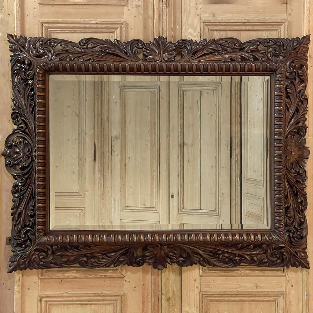 Lo specchio da parete in legno di noce intagliato del XIX secolo è la prova del talento superiore di uno scultore del legno!  Realizzata in noce pregiato, la cornice è intagliata tutt'intorno, con una conchiglia all'interno di una cresta a volute