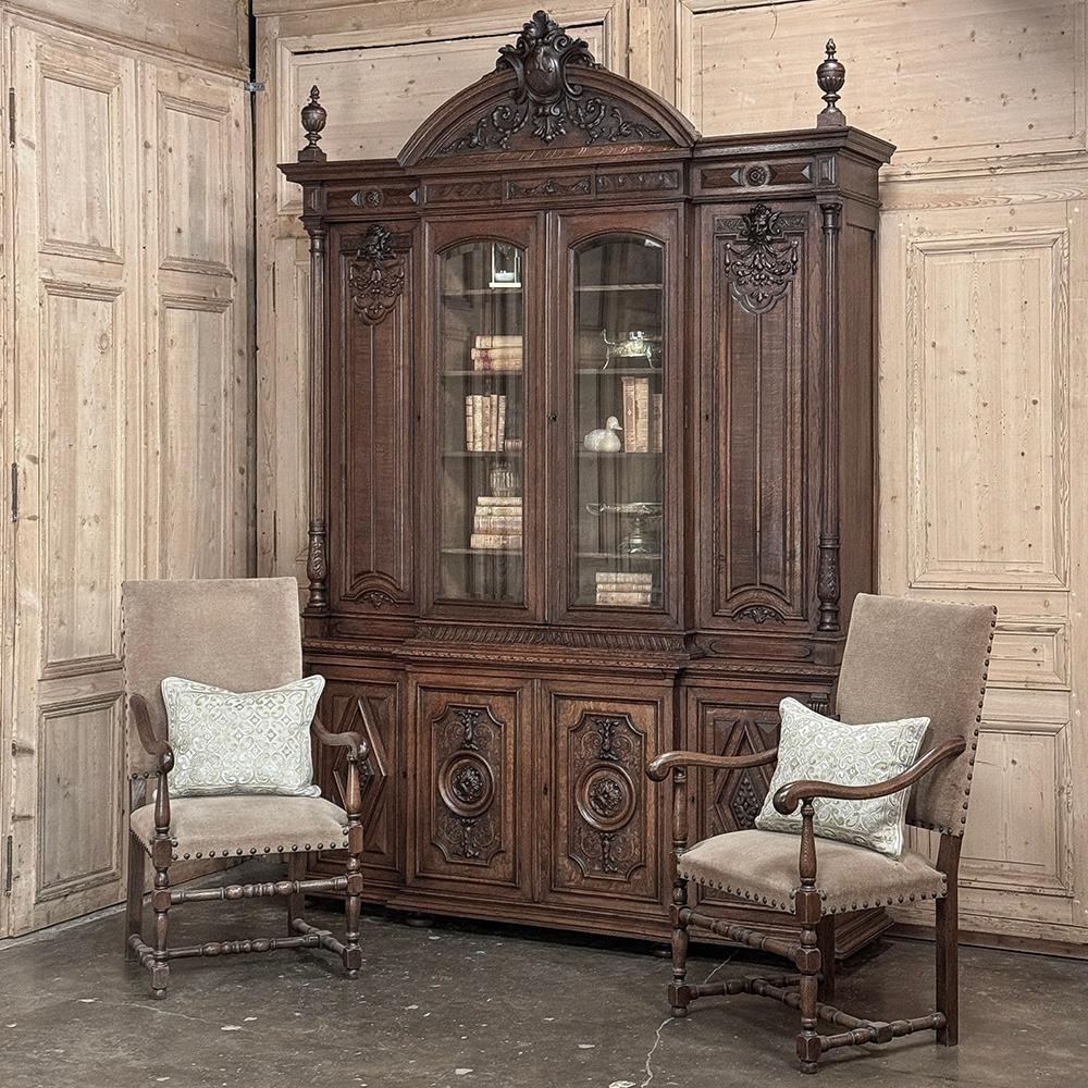 19th Century French Renaissance Grand Bookcase is a study in classical architecture rendered on a larger-than-life scale for a prominent French merchant.  The boldly arched crown is centered by an equally bold heraldic crest with descending foliates