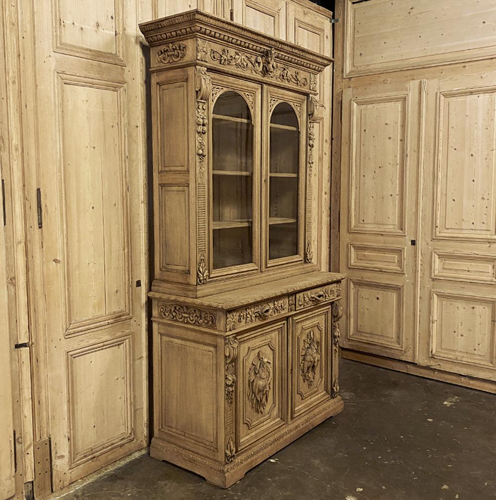19th century French Renaissance stripped hunt bookcase is a master work of the cabinetmaker's art! Rendered entirely from old-growth white oak, it features a bold crown molding with acanthus trim and egg and dart motifs appears above the bonnet