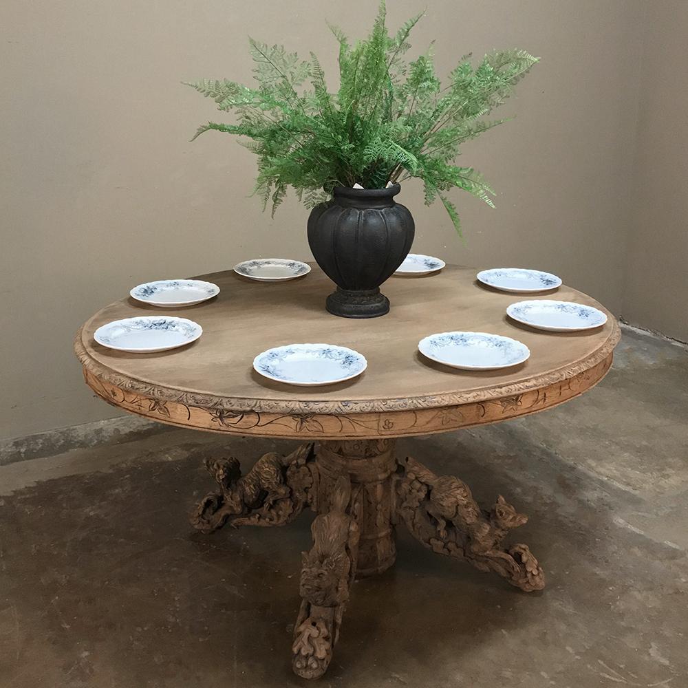 19th century French Renaissance Stripped Oak Oval Hunt Table was sculpted from solid oak, and features elaborately carved hunting dogs, a fox and a deer beautifully rendered on the scrolled legs below. Support is provided by a large carved urn style