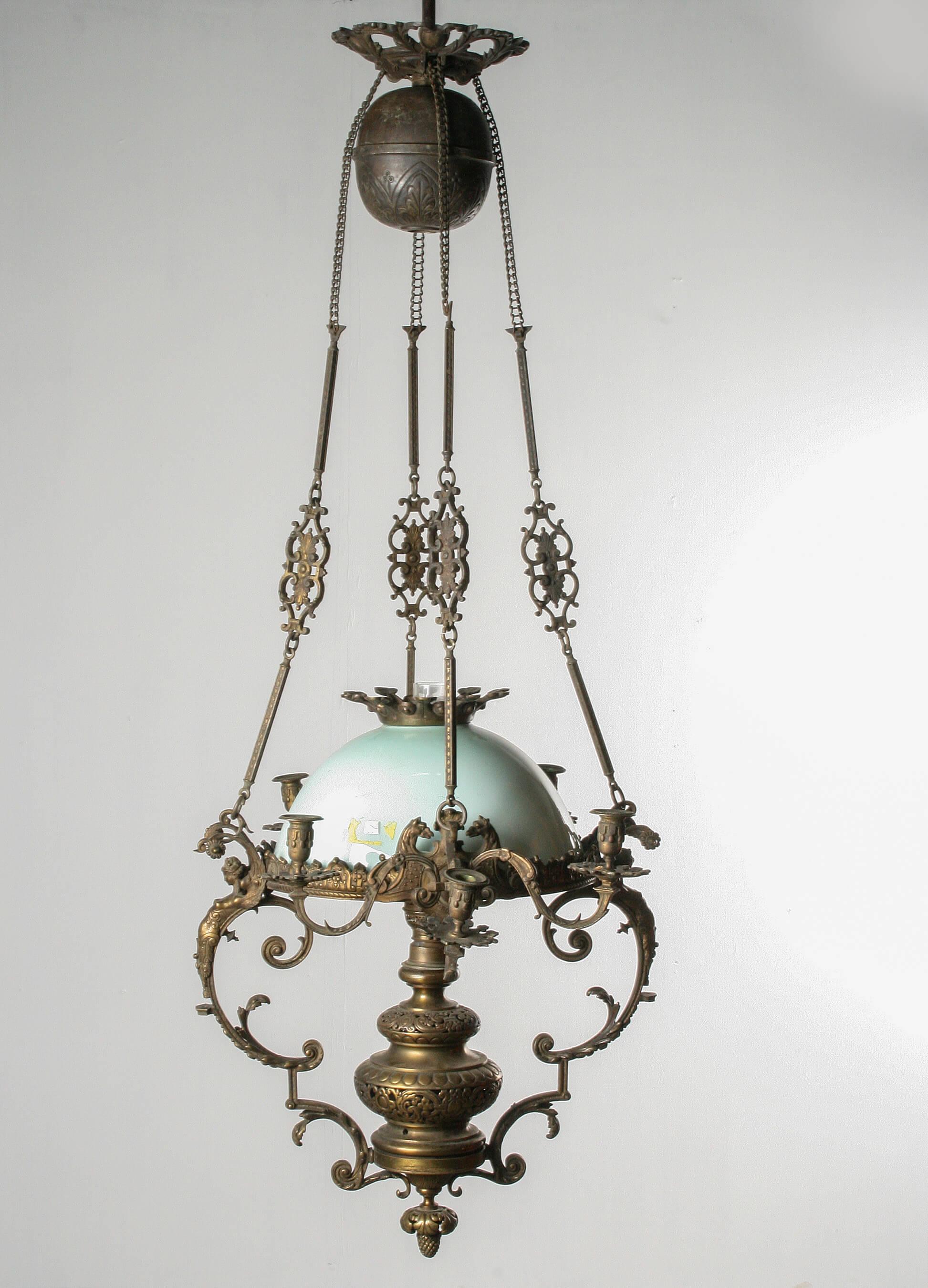 Lampe à huile de style Renaissance du 19e siècle. Conçu. J'ai deux chandeliers, chacun avec 3 bougies. Au centre, l'unité de lampe à huile. Avec un abat-jour en verre vert et une couronne en bronze. Le cadre est en bronze moulé. Décoré de femmes