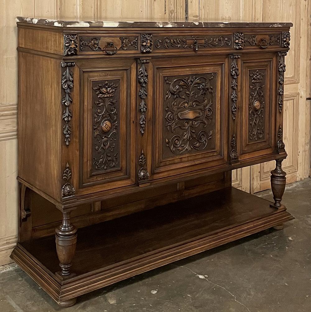 19th century French Renaissance walnut marble top raised buffet is a celebration of the style, with stylized interpretations of naturalistic forms that are truly amazing to behold! Whimsical Norsemen appear where normally rosettes would be carved