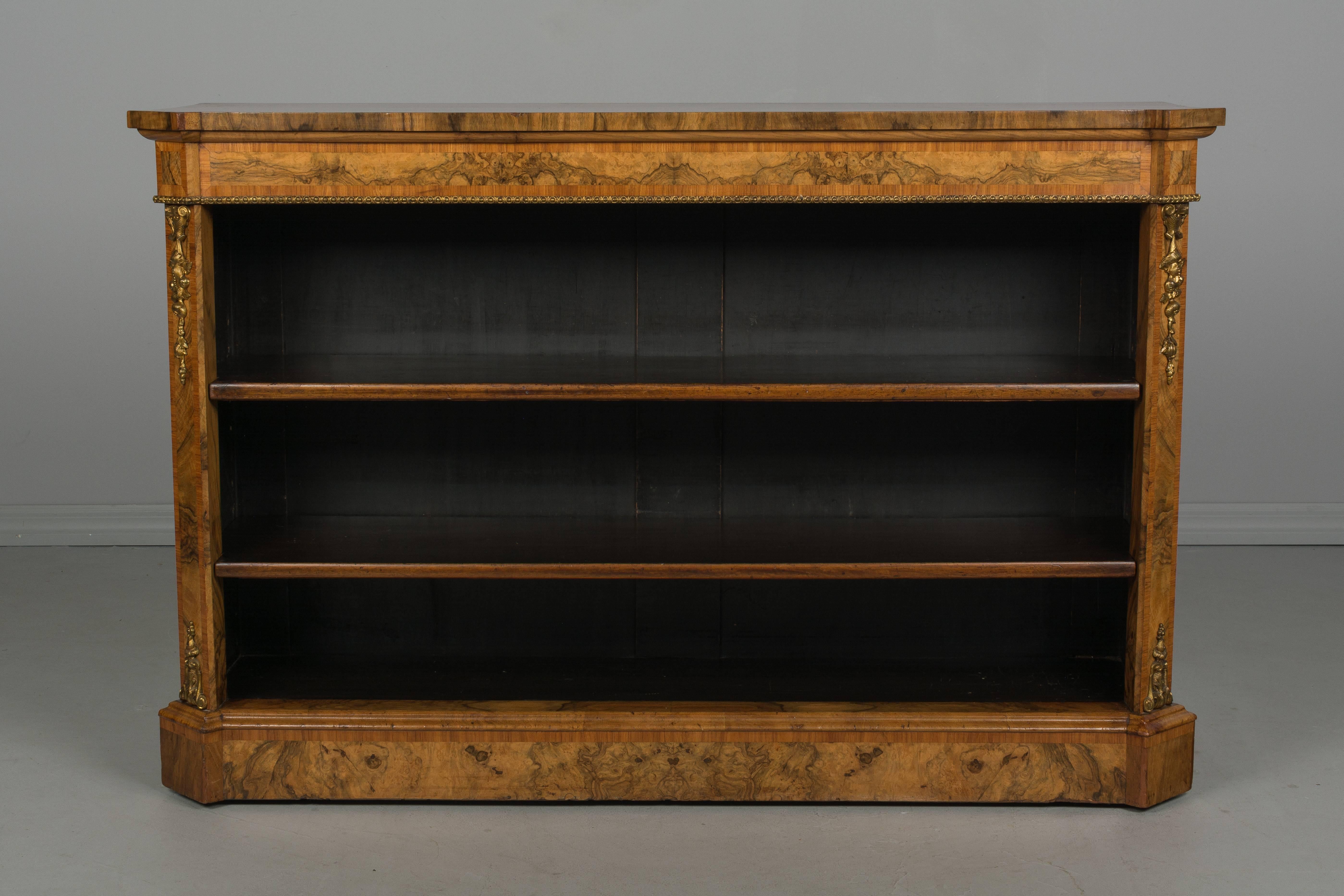 A fine late  19th century French Restauration style bookcase made of bookmatched veneer of burled walnut with bronze corner decorations and trim. Dark stained interior with two adjustable shelves, 11
