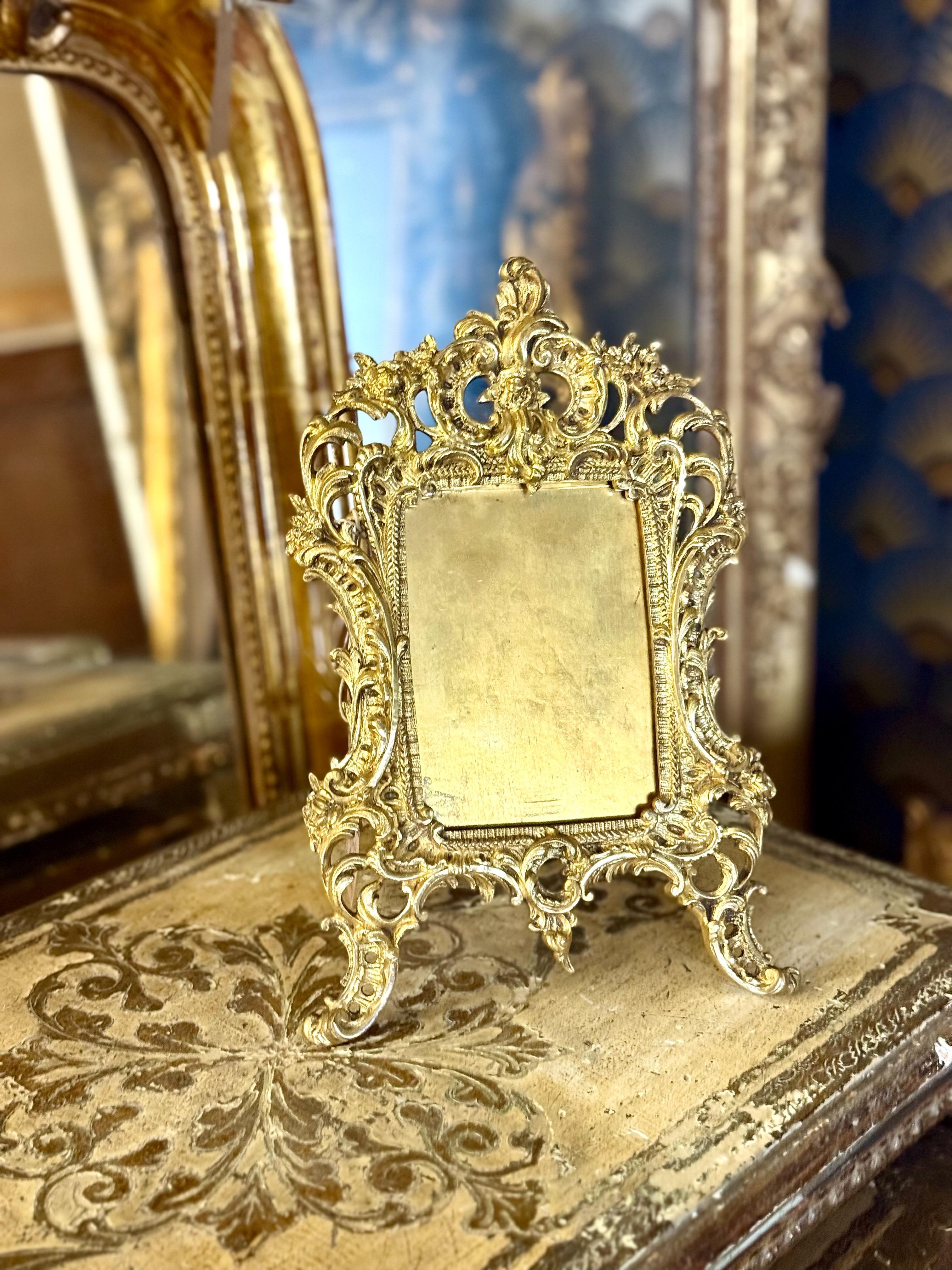 This magnificent 19th-century French gilt bronze tabletop frame is an exceptional example of Rococo artistry, distinguished by its exuberant curves, openwork patterns, and finely sculpted ornamentation. Crafted with remarkable precision, the frame