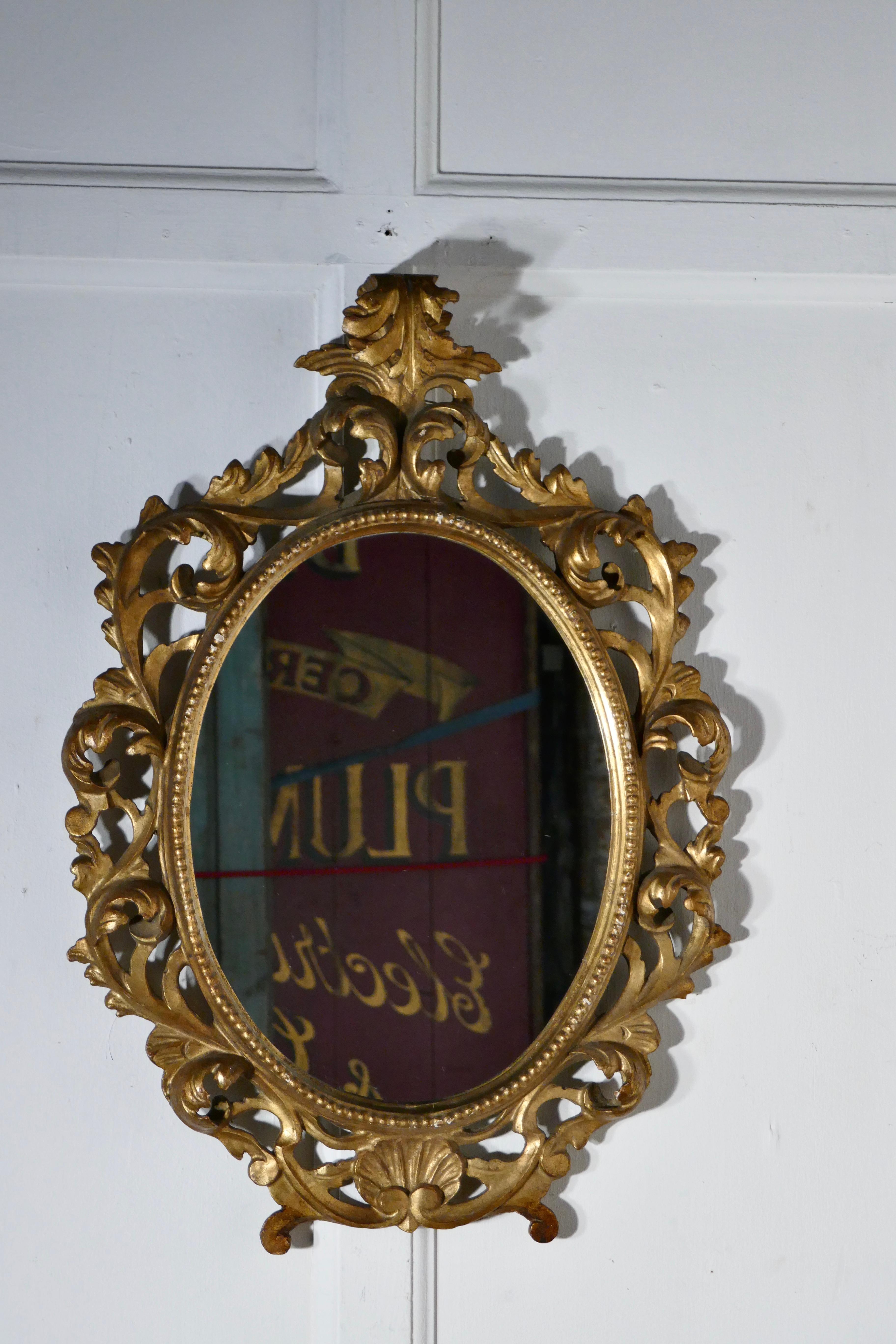 19th century French Rococo gilt wall mirror 

This is a beautifully Decorative Rococo gold frame mirror it is a very pretty shape with heavy gilded deep carving
The frame is intricately carved in 3D with scrolls and curling leaves, the gilt