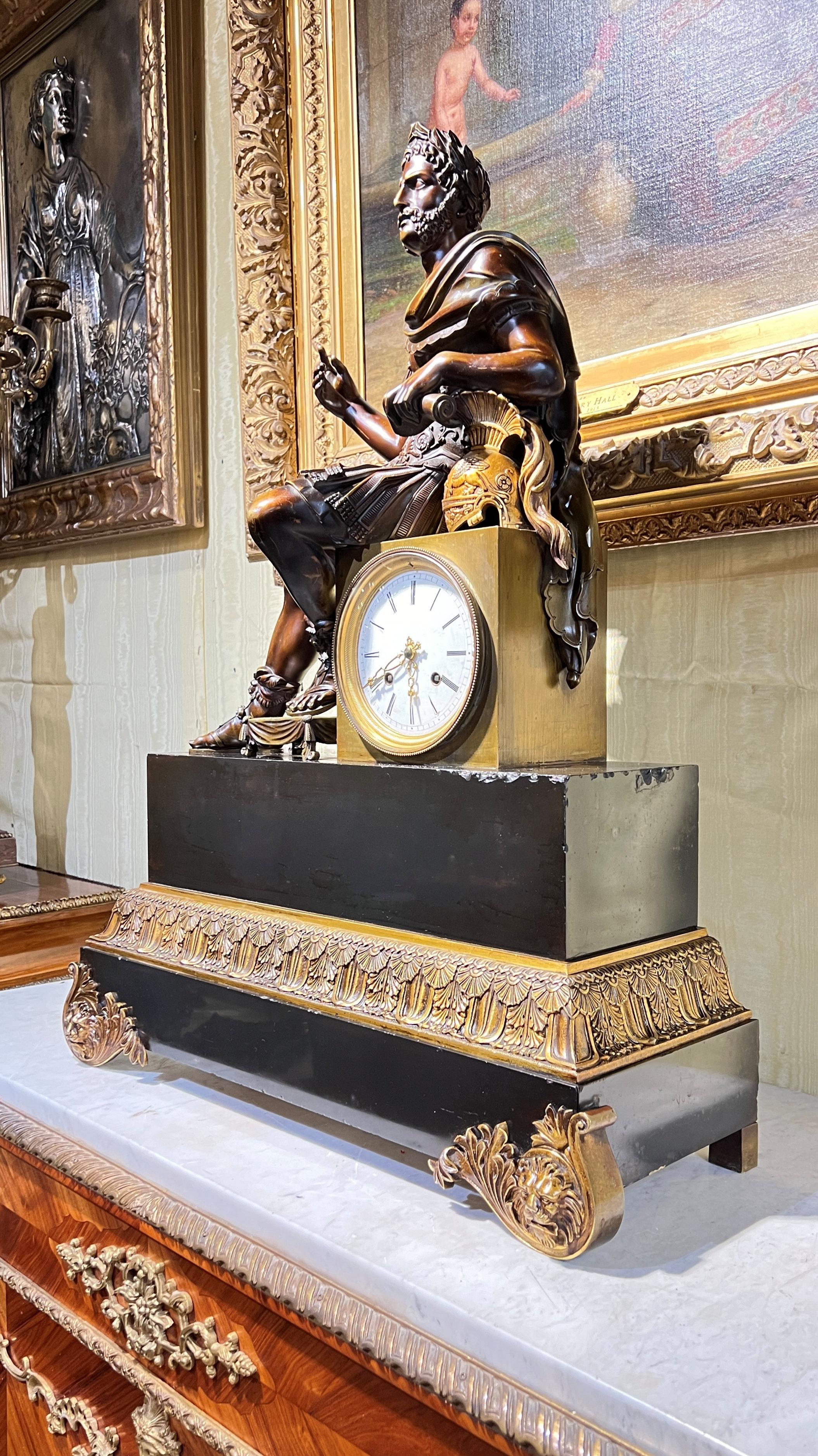Very large (28 inch tall) antique French mantel clock featuring the finely modeled and cast bronze figure of a seated Roman general with beautiful patina, with frame cut from solid black slate wit gilt bronze mounts.  Figure's long spear, (held in