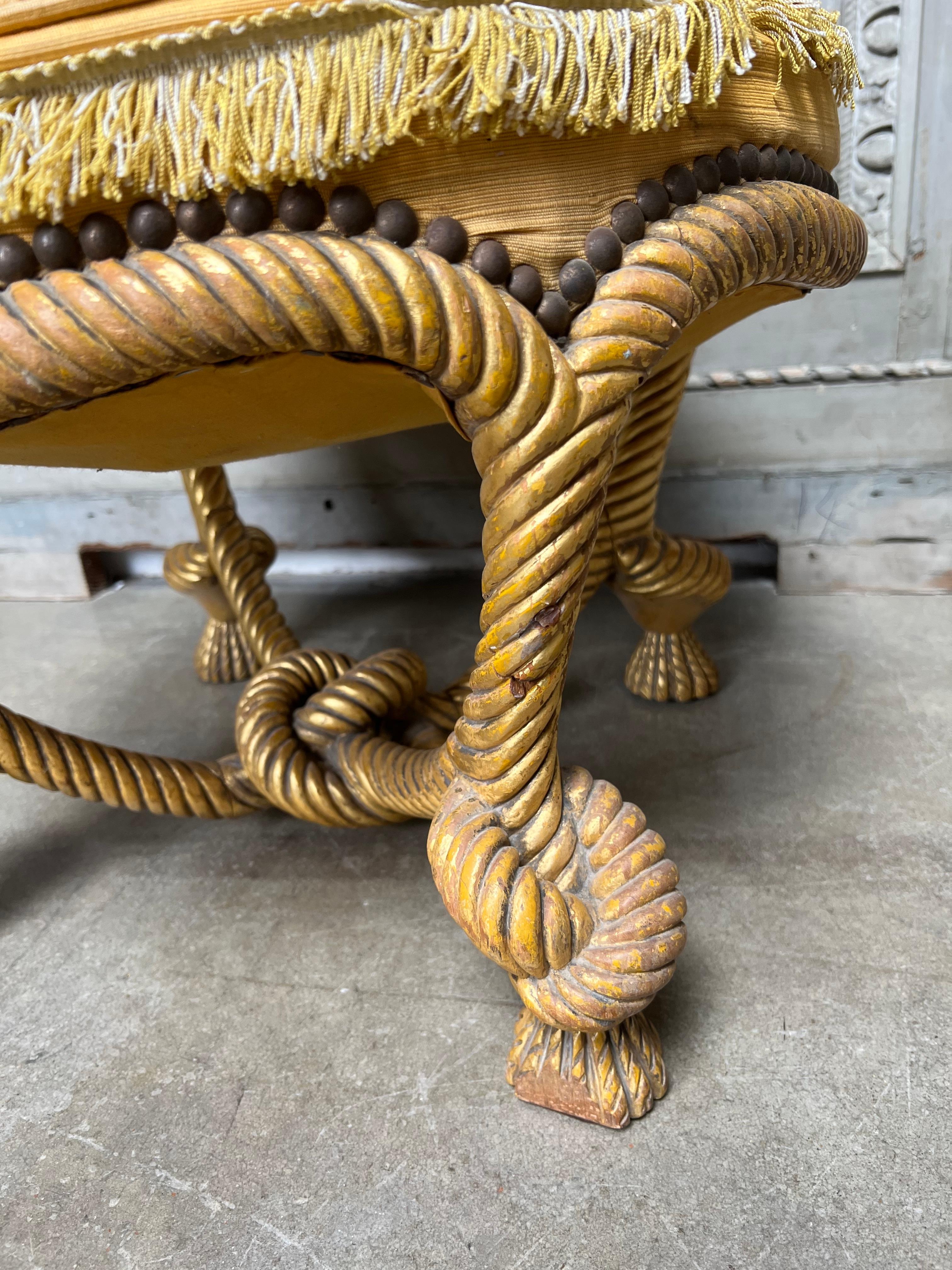 A French gilt wood Napoleon III pouf in carved wood in the shape of a tied rope. 
This ottoman is very decorative and is original state. It has a needlepoint top that can be used but was detached to removed the horse hair for international