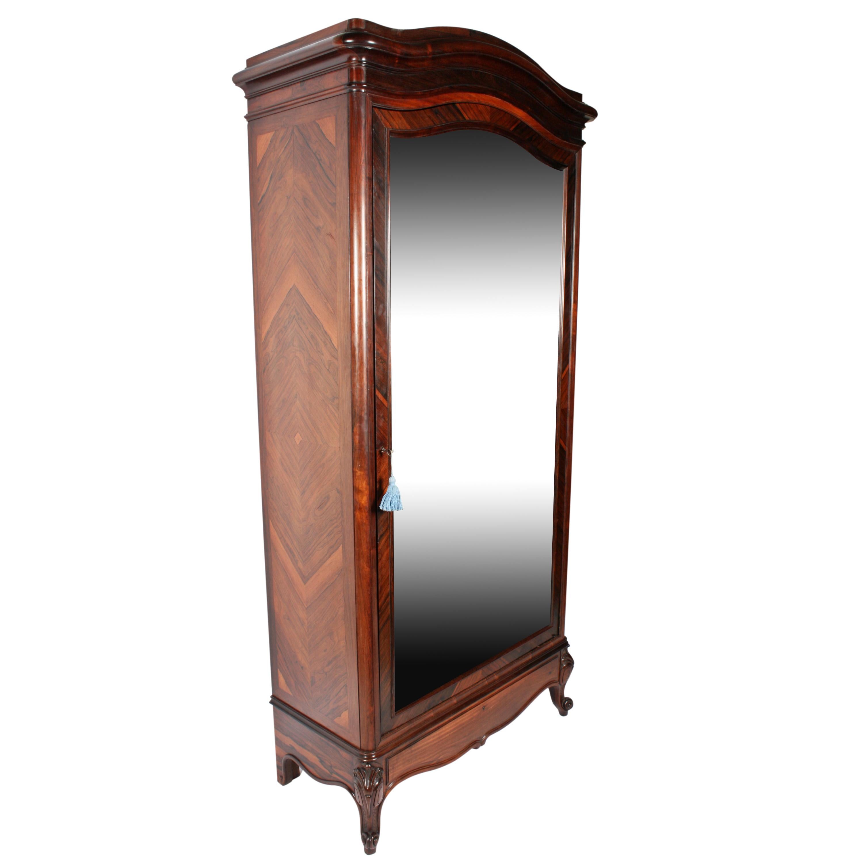 A 19th century French rosewood mirror door armoire by the Paris cabinet makers Moulin, signed on the reverse. .

The large single door has a bevelled edge mirror, is serpentine in shape at the top edge and the reverse side is panelled in bird eye