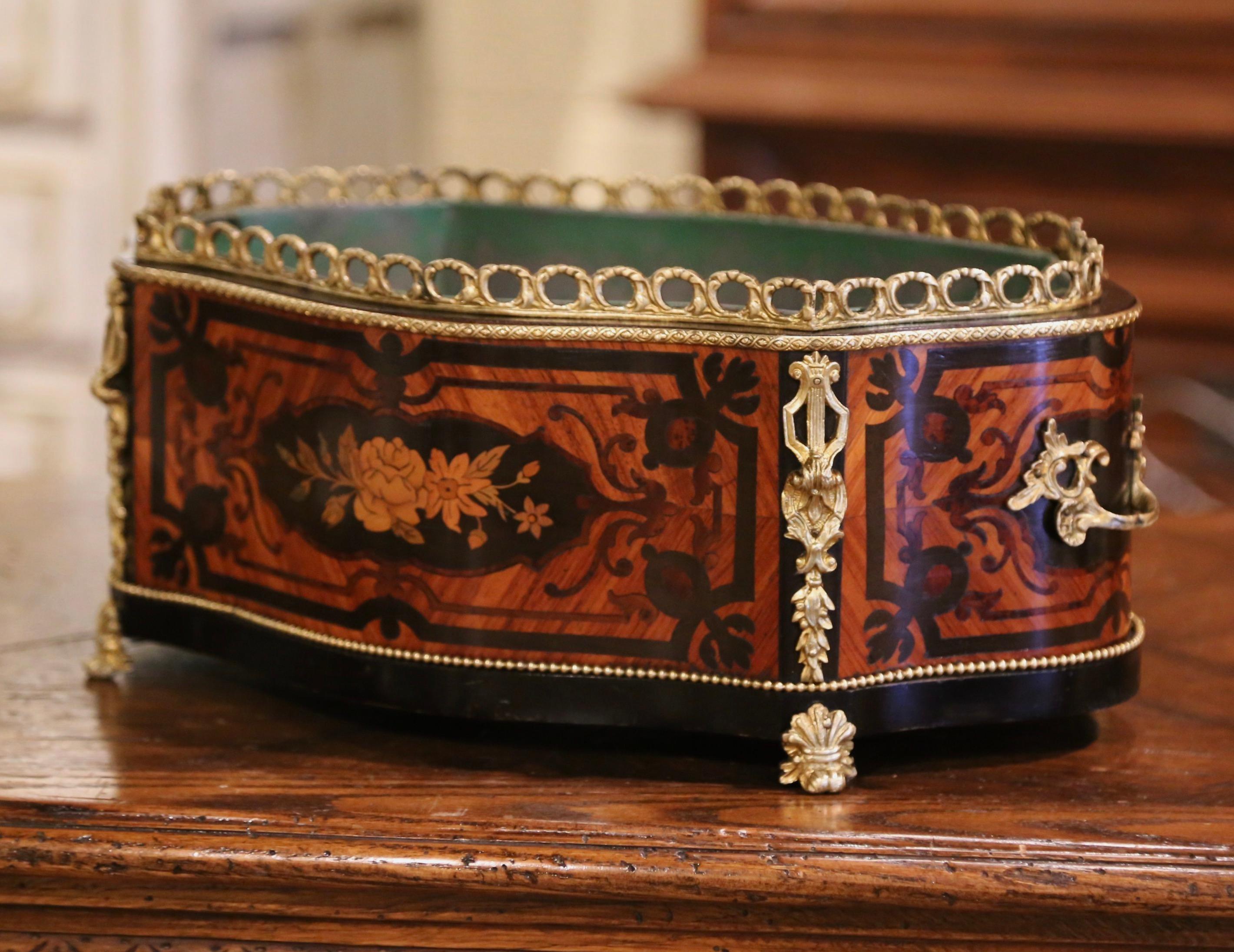 This elegant oval planter was crafted in Paris, France circa 1870. The antique, rosewood and ebony jardinière with serpentine front and bombe sides dressed with handles, features marquetry and parquetry motifs including a very detailed inlay