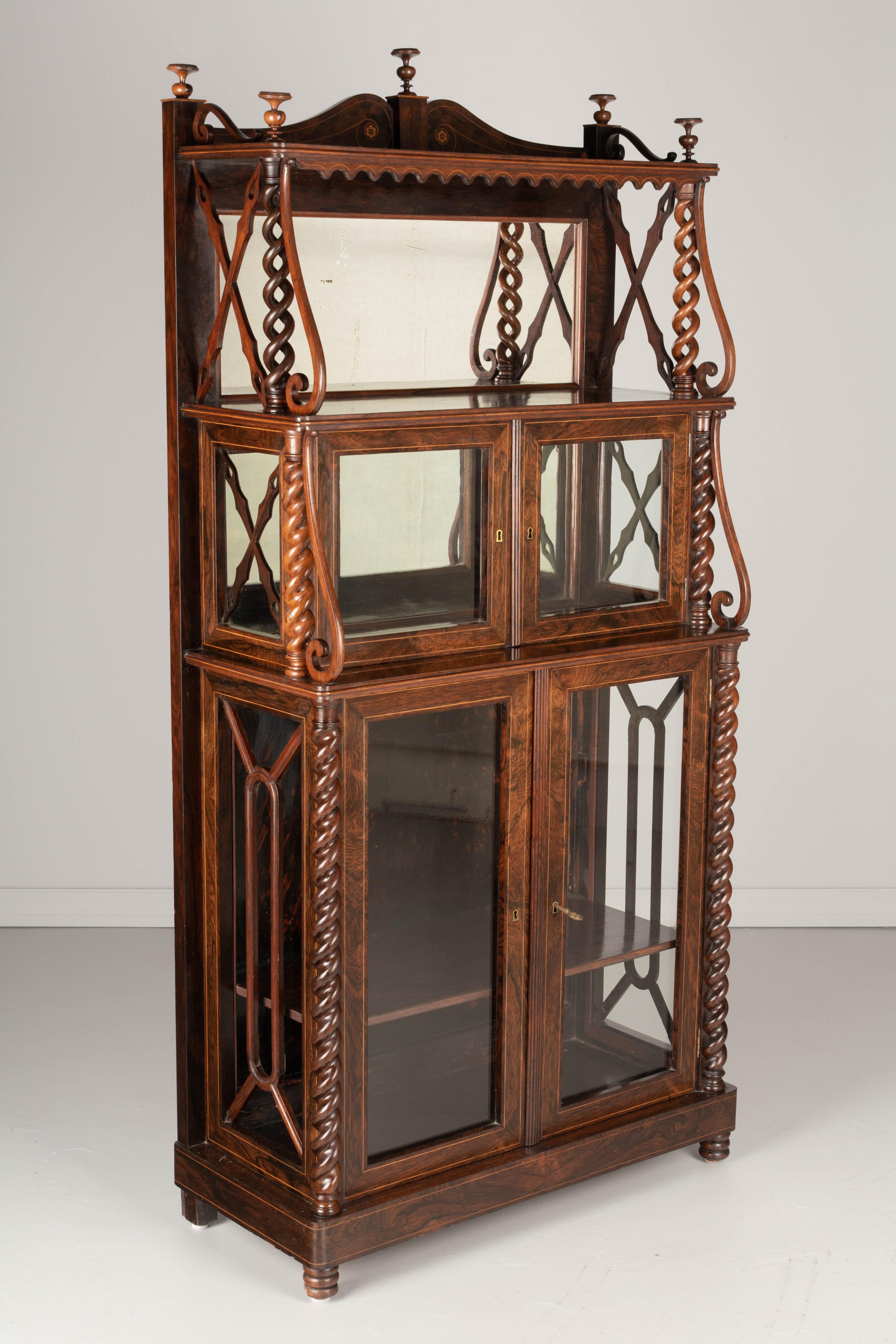 A 19th Century French Louis Philippe étagère, or display cabinet with shelves. Made of solid rosewood with fine lemon wood marquetry inlay borders and rosettes. Good quality craftsmanship with carved barley twist columns and delicate turned finials.