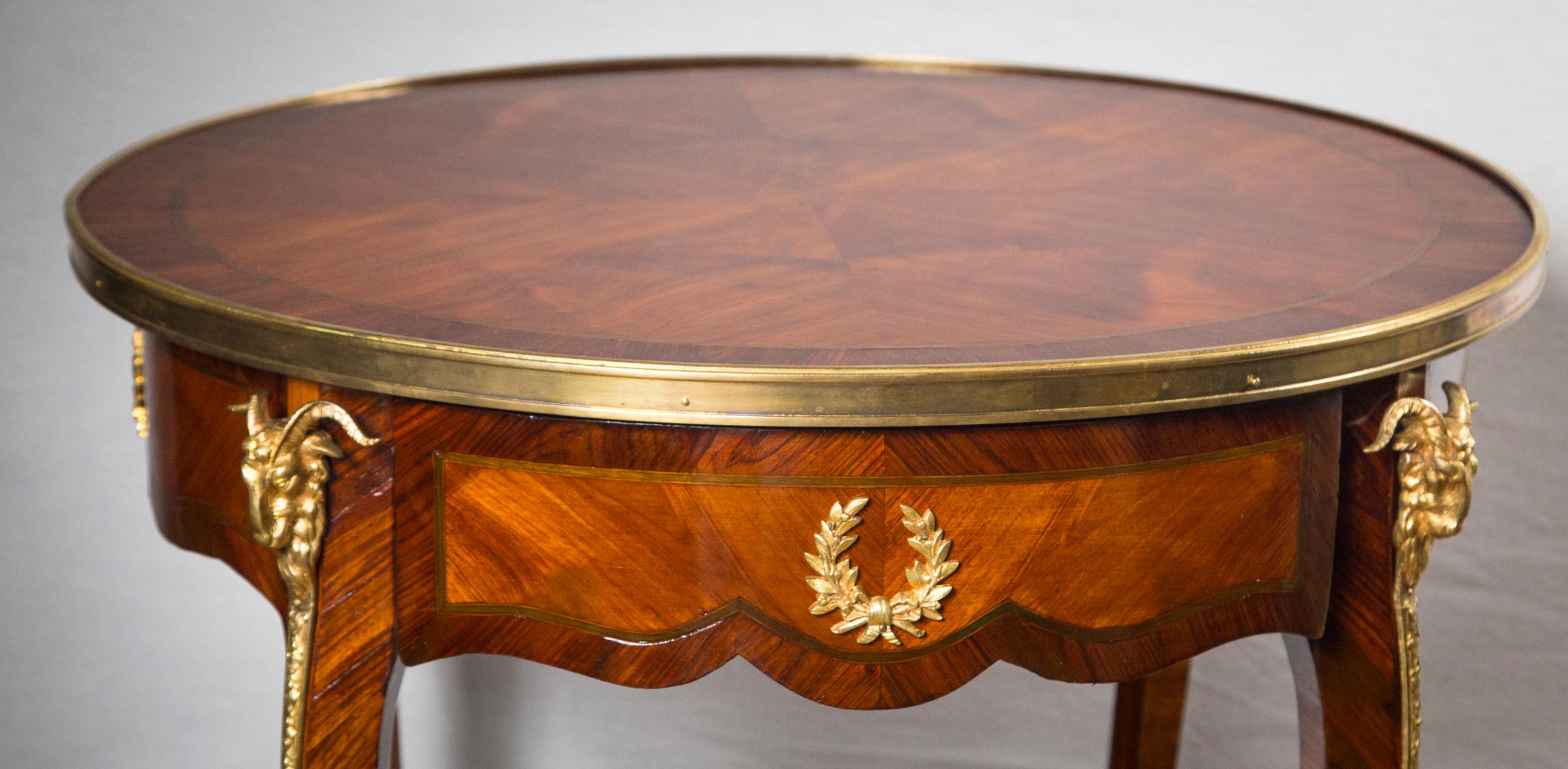 Made of dark and light mahogany veneers with a possible sycamore narrow ring inlay on the top tier.
Gilt bronze mounts of rams heads, and laurel wreath. One drawer. Scalloped apron. Recently refinished.
Lower shelf has a diameter of 22.5 inches.