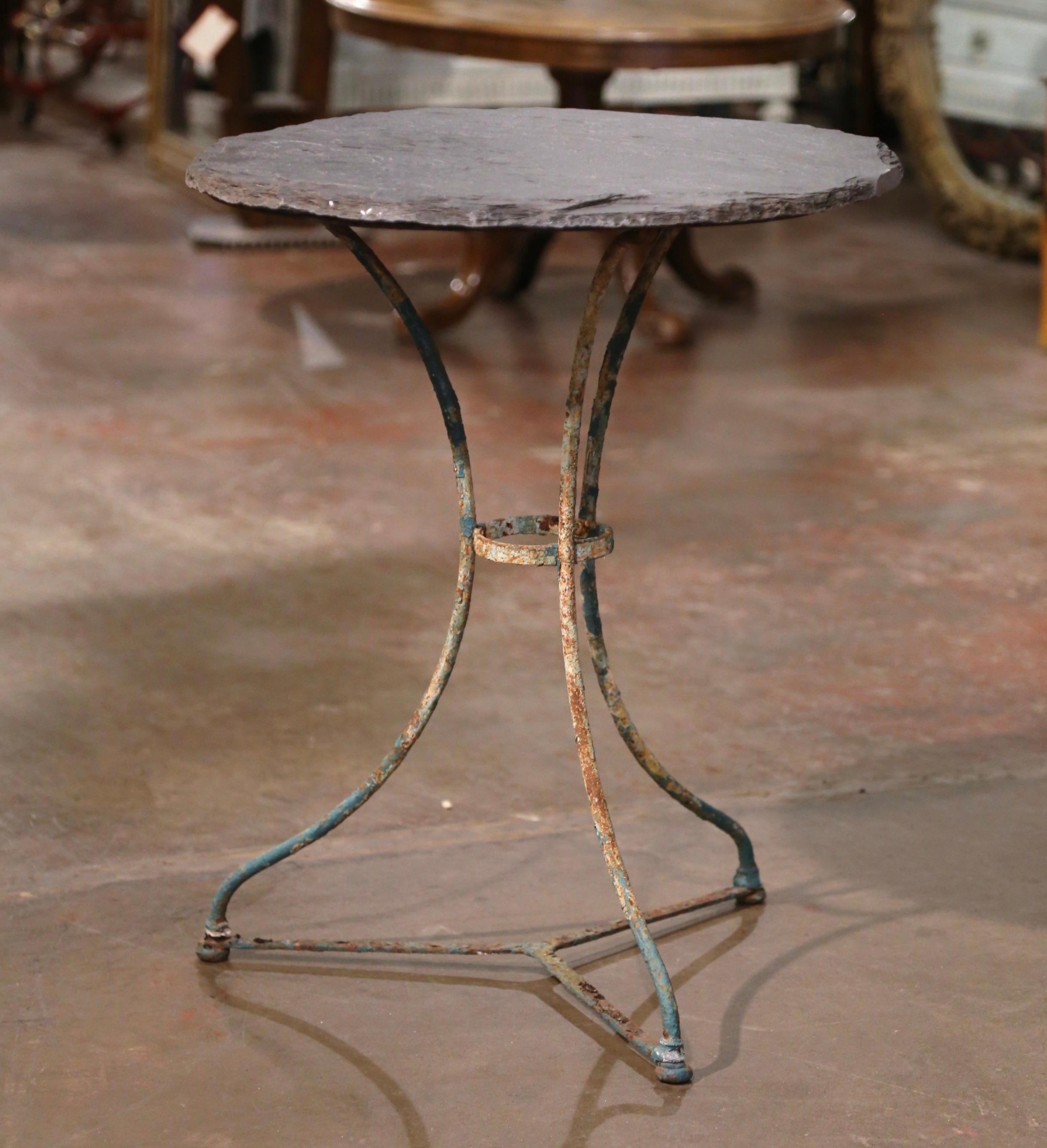 Dekorieren Sie eine Terrasse oder eine überdachte Veranda mit diesem eleganten antiken runden Bistrot-Tisch. Der um 1870 in Frankreich gefertigte Tisch aus Gusseisen steht auf drei mit einer runden Bahre verbundenen Schneckenbeinen. Die Tischplatte